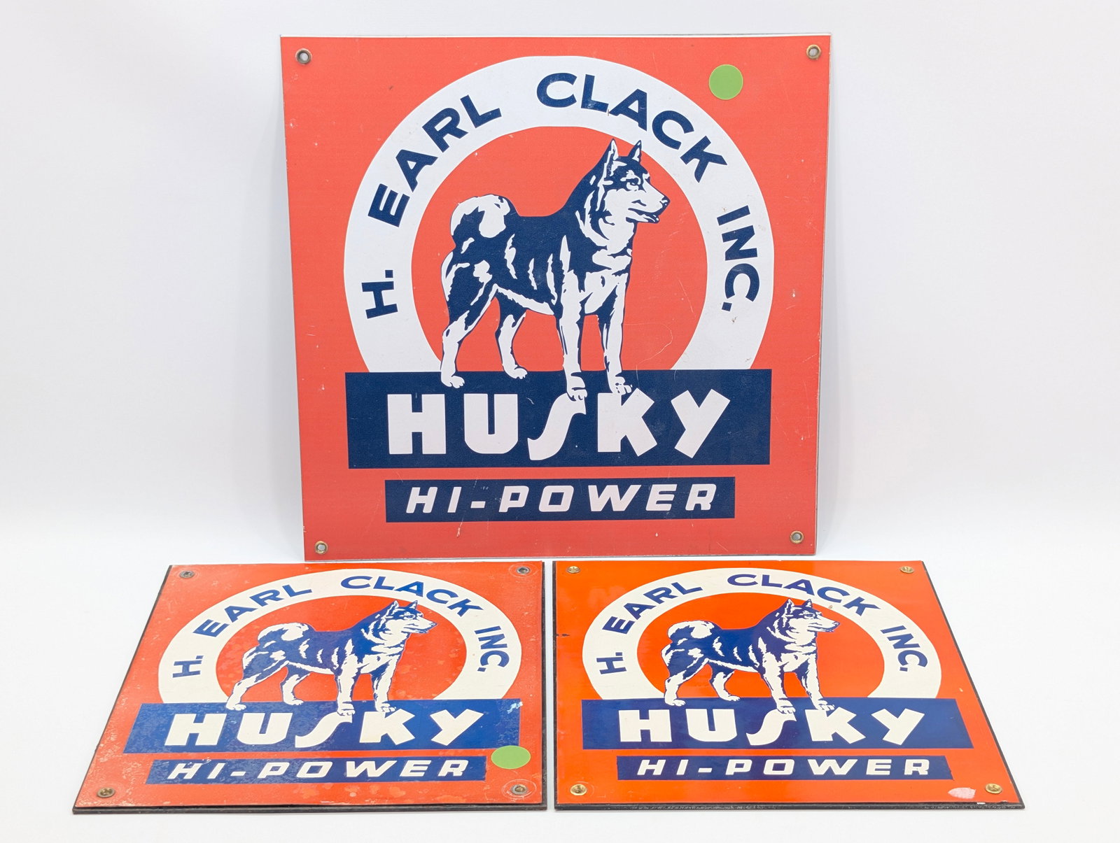 3) REPRODUCTION H. EARL CLACK INC. HUSKY MOTOR OIL SIGNS: ALL REMAIN IN GOOD CONDITION, SHOWING SOME TYPICAL WEAR.