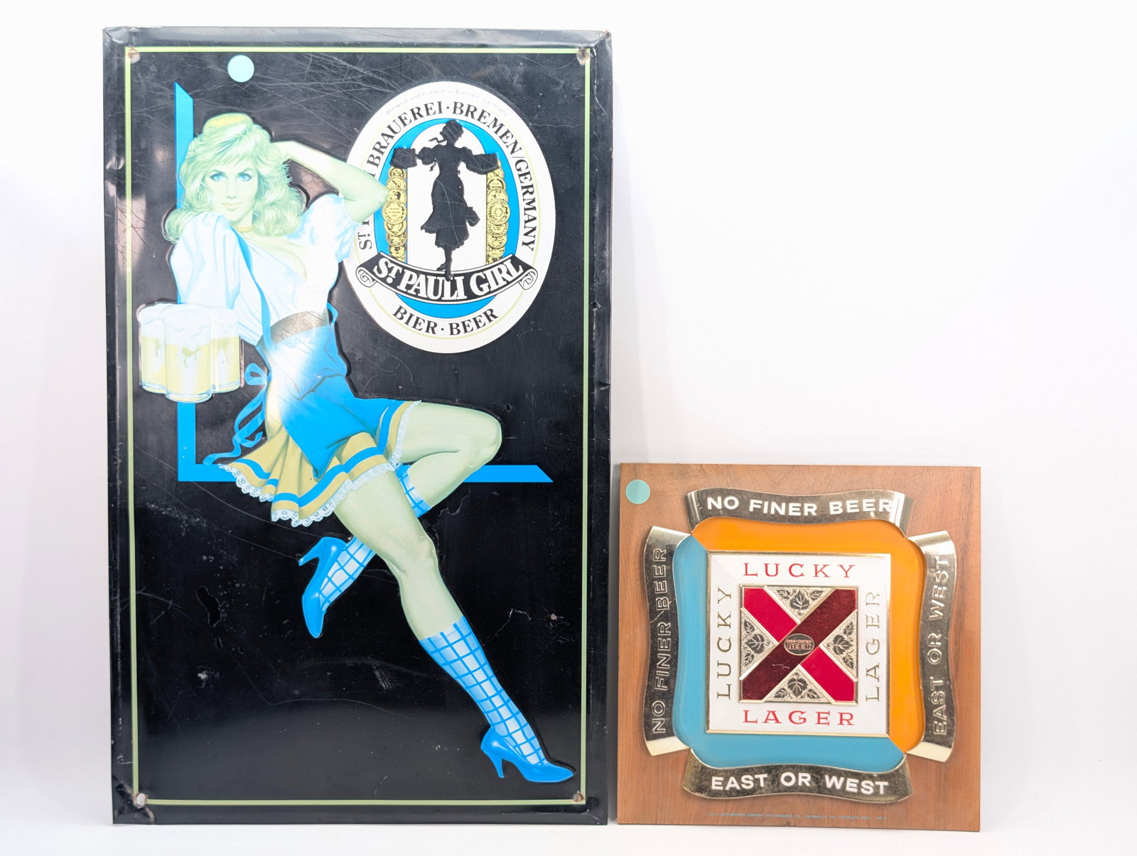 LUCKY LAGER & ST. PAULI GIRL BEER SIGN: ST. PAULI GIRL SIGN SHOWING WEAR WITH SCRATCHES. LUCKY LAGER PLASTIC SIGN REMAINS IN GOOD CONDITION.