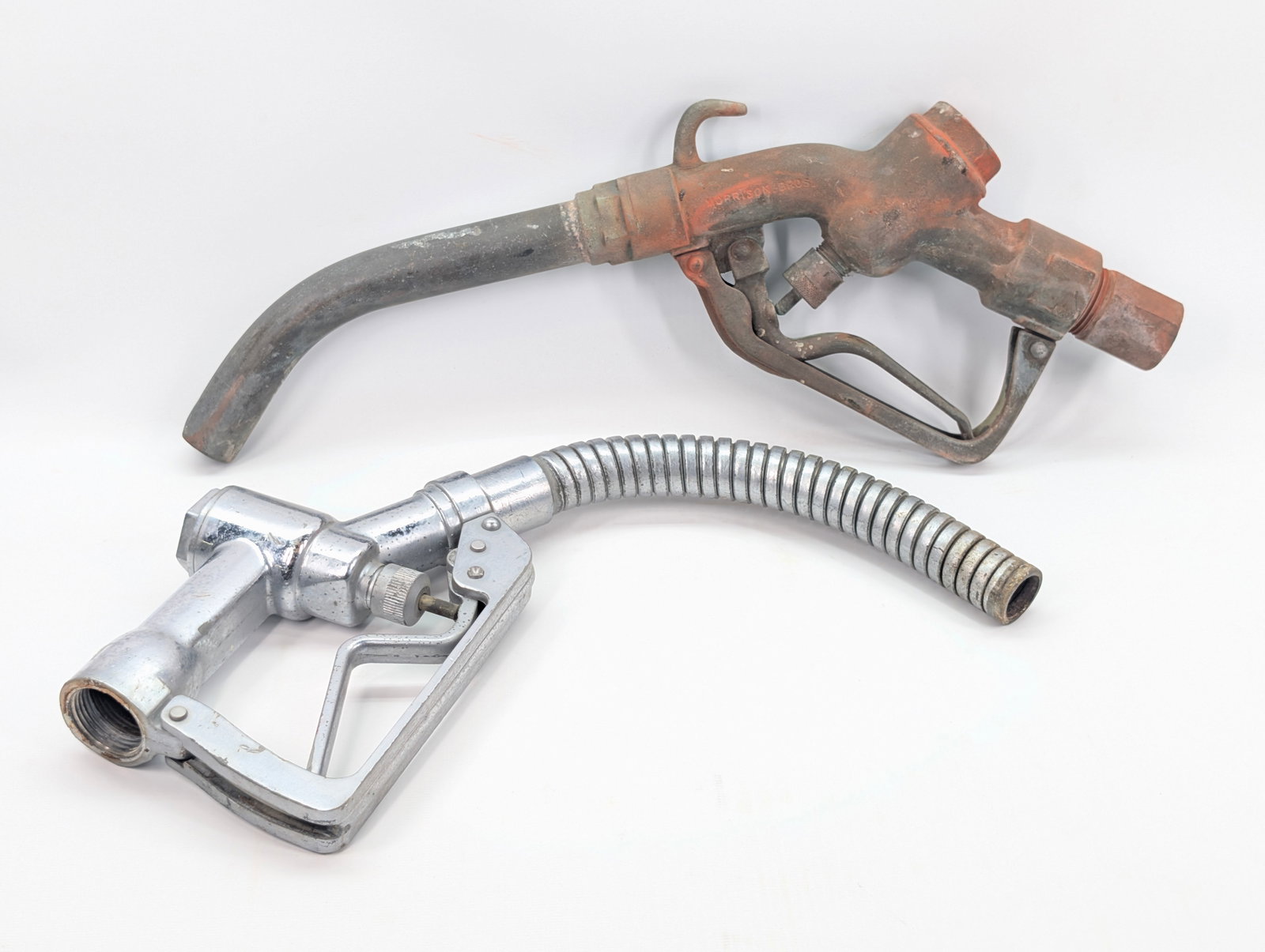 2) VINTAGE GAS PUMP NOZZLES: BOTH REMAIN IN FAIR TO GOOD CONDITION, SHOWING SOME TYPICAL WEAR.