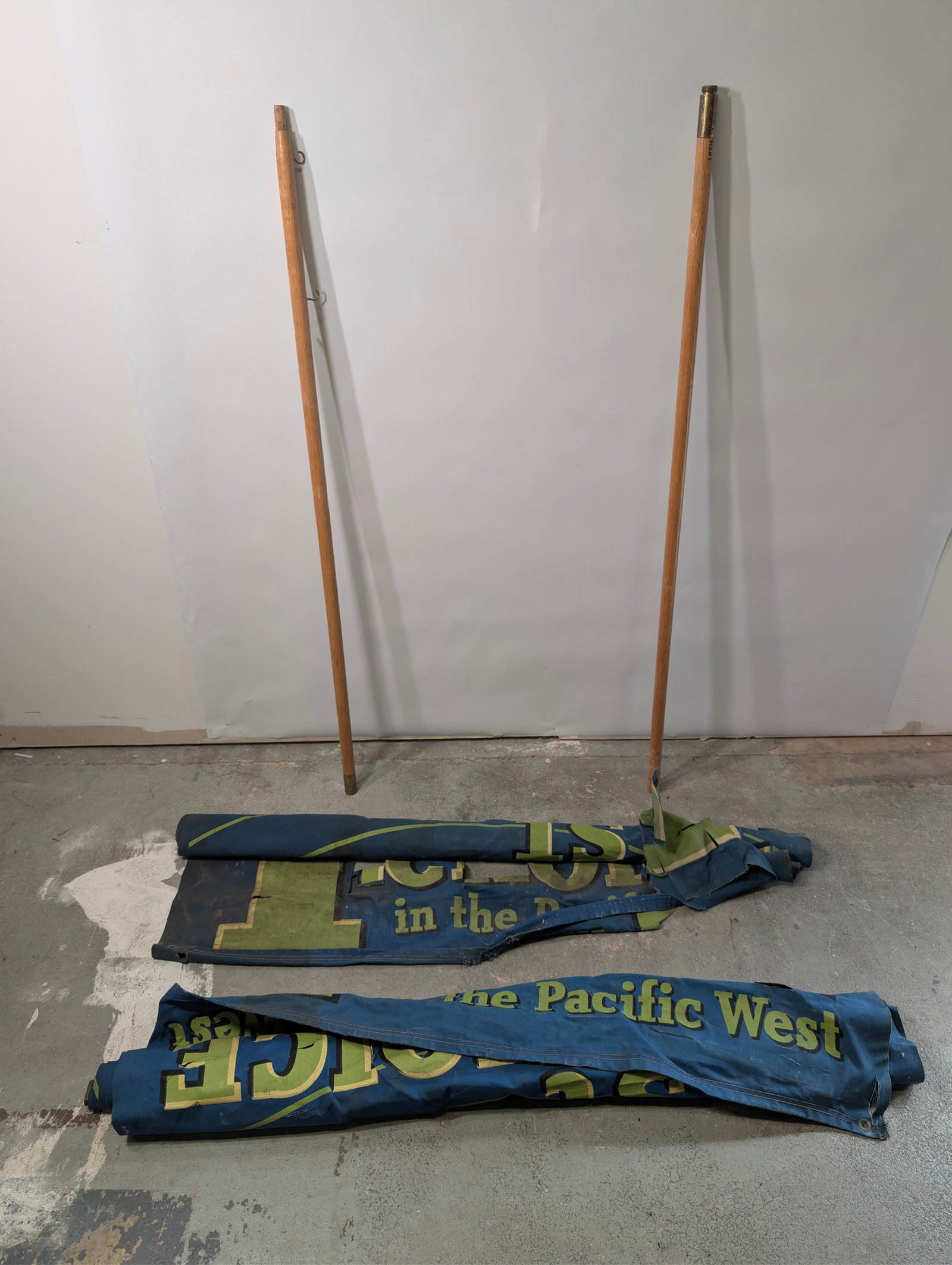 2) LARGE RPM MOTOR OIL CANVAS BANNERS: ONE REMAINS IN GOOD CONDITION, SHOWING SOME TYPICAL WEAR WITH SOME STAINS. THE OTHERS IN FAIR CONDITION, SHOWING WEAR WITH HOLES AND SMALL PIECES MISSING. STAINS THROUGHOUT.