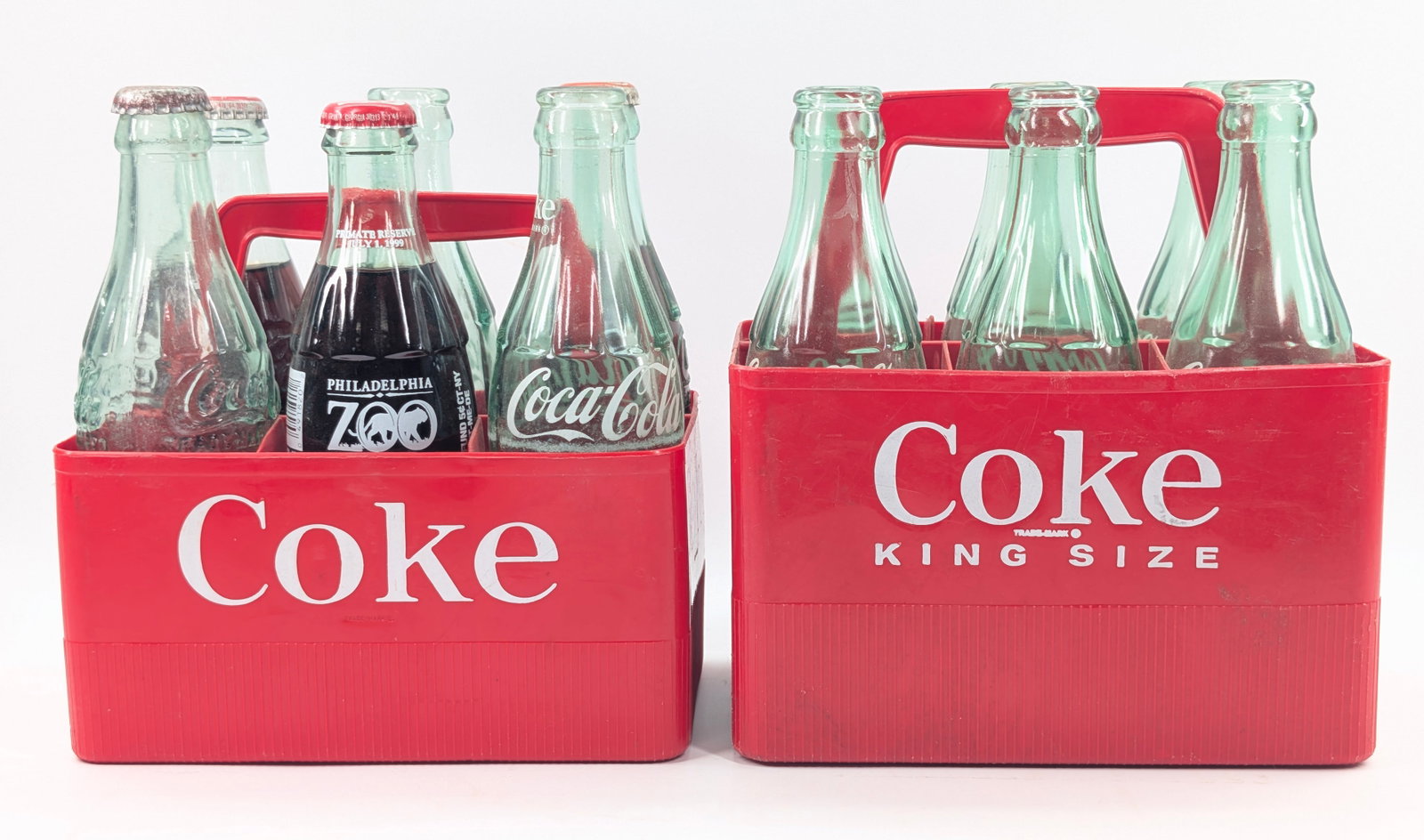 2) PLASTIC COCA COLA CARRIERS W/ BOTTLES: REMAINS IN GOOD CONDITION.