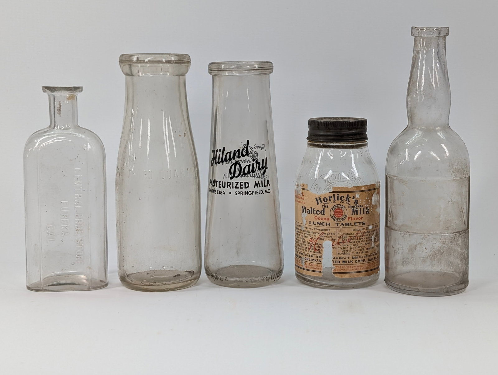ASSORTED LOT OF VARIOUS MILK BOTTLES: ALL REMAIN IN GOOD CONDITION, SHOWING SOME TYPICAL WEAR. NEED CLEANED. ONE BOTTLE WITH CHIP.