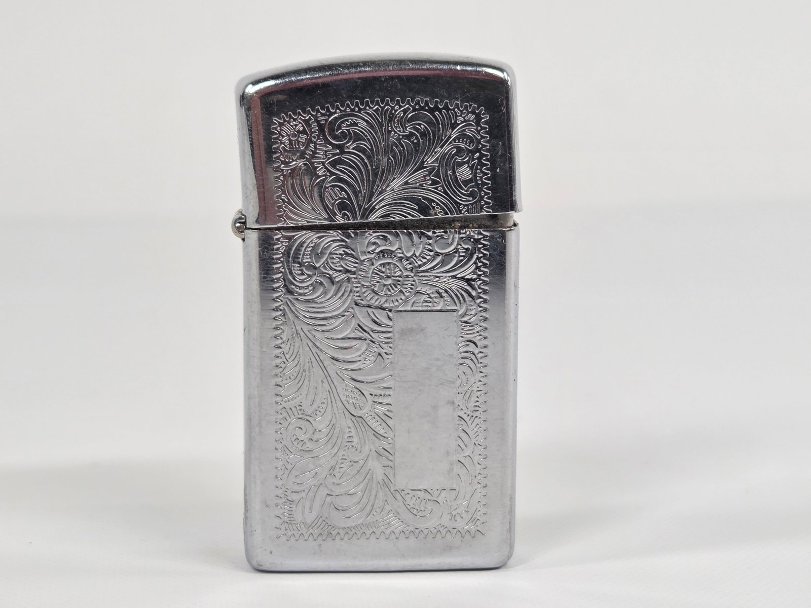 VINTAGE SLIM ZIPPO LIGHTER: REMAINS IN FAIR TO GOOD CONDITION, SHOWING TYPICAL USAGE WEAR.