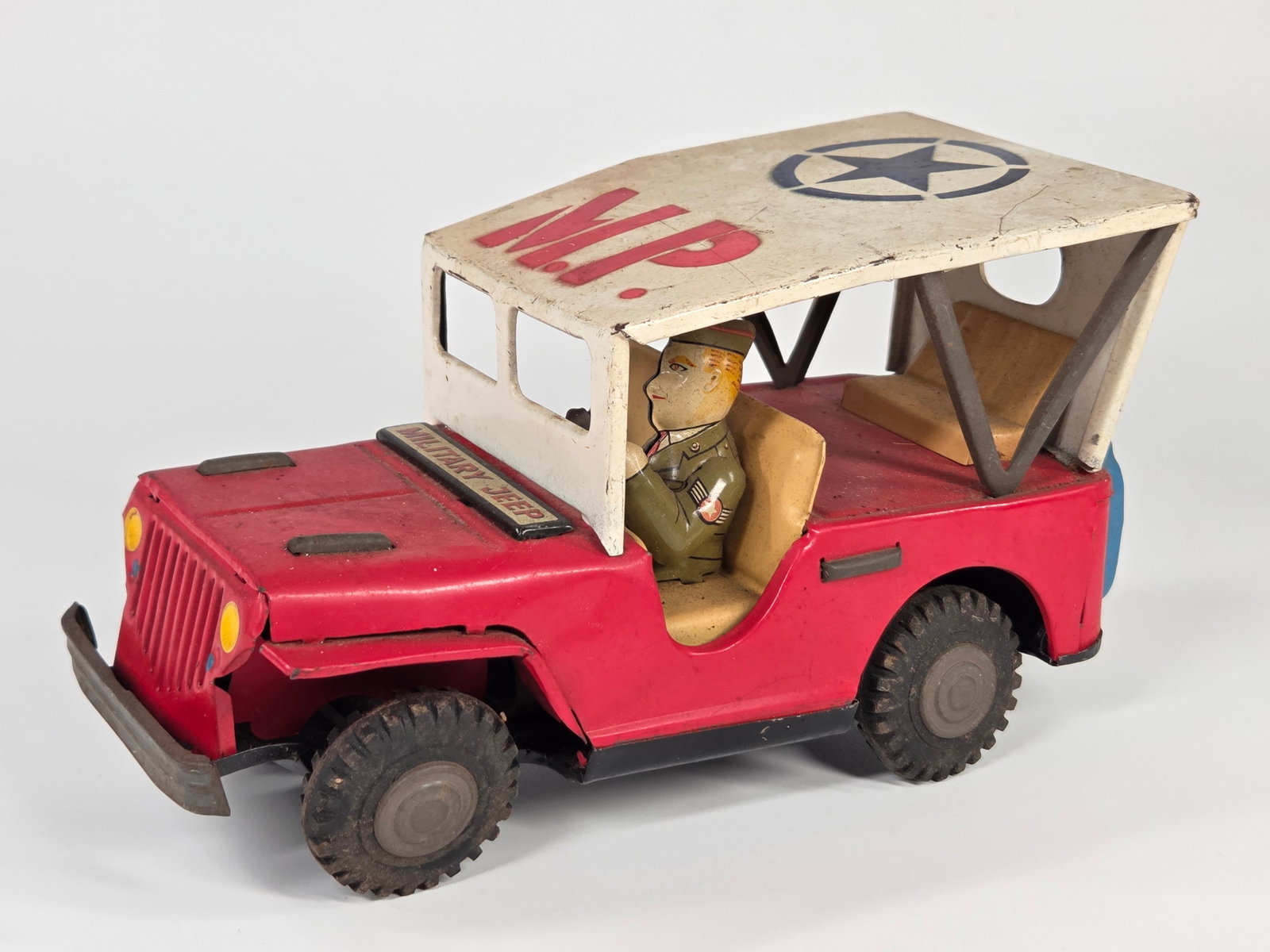 JAPAN TIN FRICTION RED MILITARY POLICE JEEP: REMAINS IN FAIR TO GOOD CONDITION, SHOWING TYPICAL USAGE WEAR. FRICTION MOTOR WORKS.