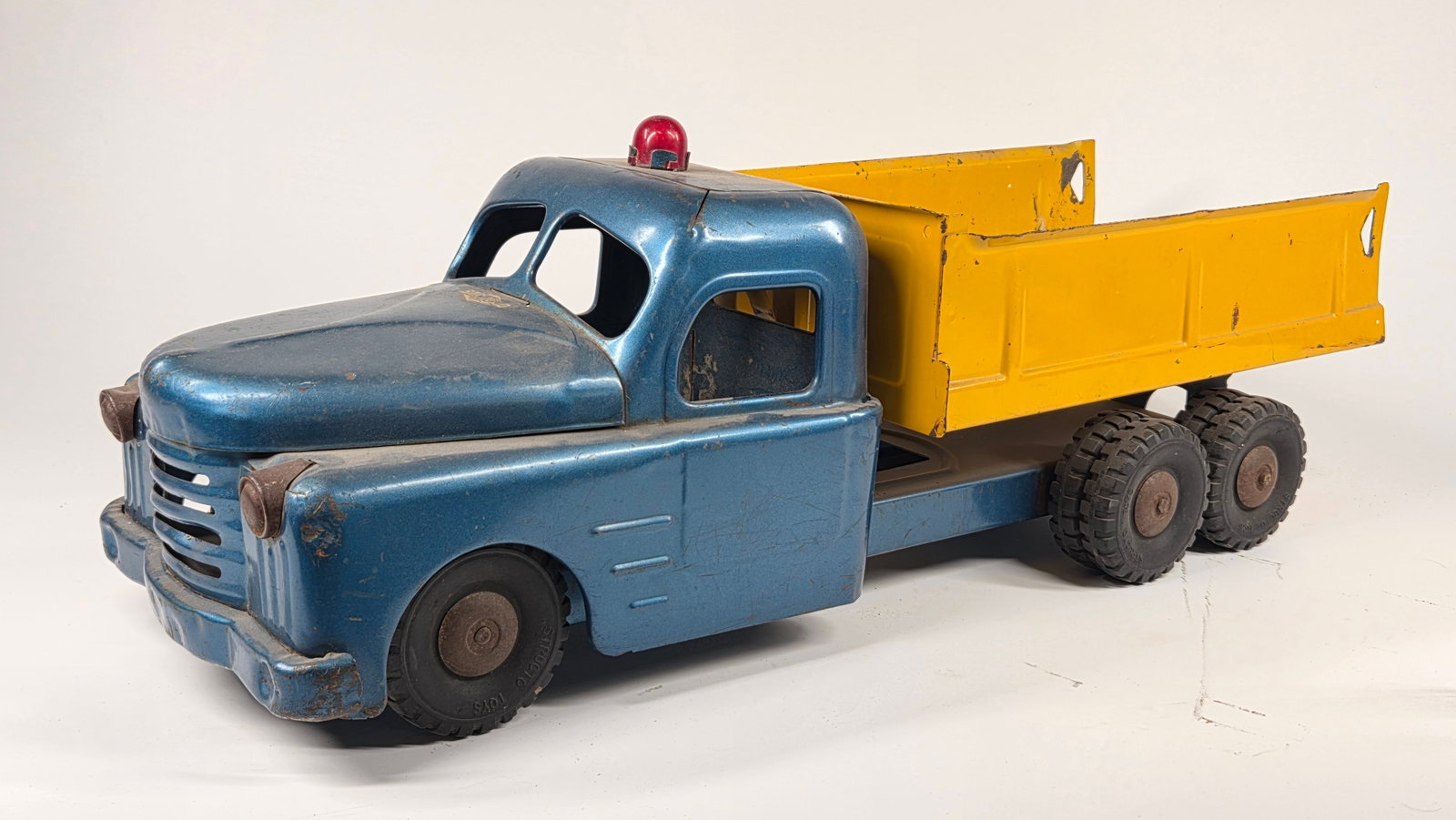 STRUCTO PRESSED STEEL DUMP TRUCK: REMAINS IN FAIR TO GOOD CONDITION, SHOWING SOME TYPICAL WEAR. MISSING REAR SWING GATE. DUSTY, NEEDING CLEANED.