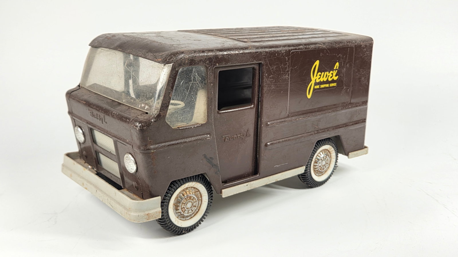 BUDDY L PRESSED STEEL JEWEL SHOPPING SERVICE PRIVATE LABEL TRUCK: REMAINS IN FAIR CONDITION, SHOWING WEAR THROUGHOUT. A FEW CRACKS IN THE GREY PLASTIC CHASSIS. MISSING REAR DOOR. BOTH SLIDING DOORS INCLUDED.
