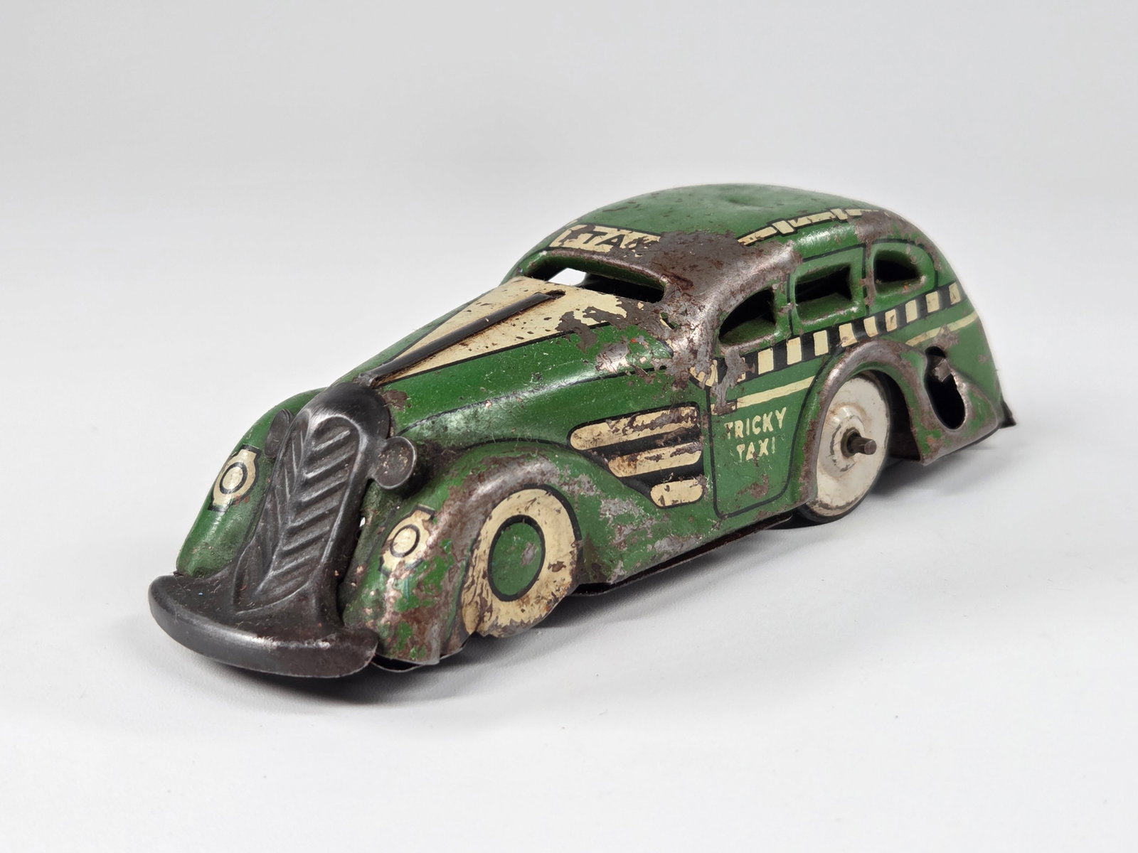 GREEN MARX WIND UP TRICKY TAXI: REMAINS IN FAIR CONDITION, SHOWING TYPICAL WEAR THROUGHOUT. UNTESTED.