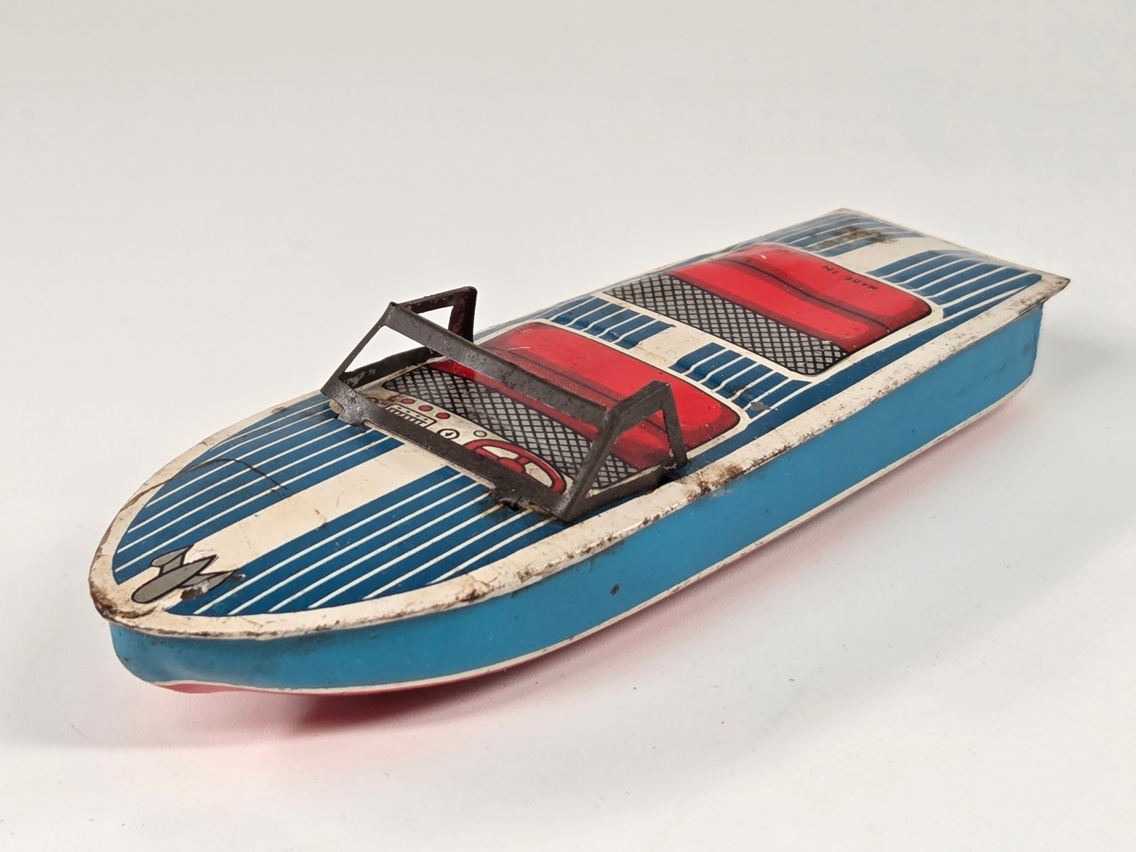 VINTAGE JAPAN TIN FRICTION BOAT: REMAINS IN FAIR TO GOOD CONDITION, SHOWING SOME TYPICAL USAGE WEAR. FRICTION MOTOR WORKS.