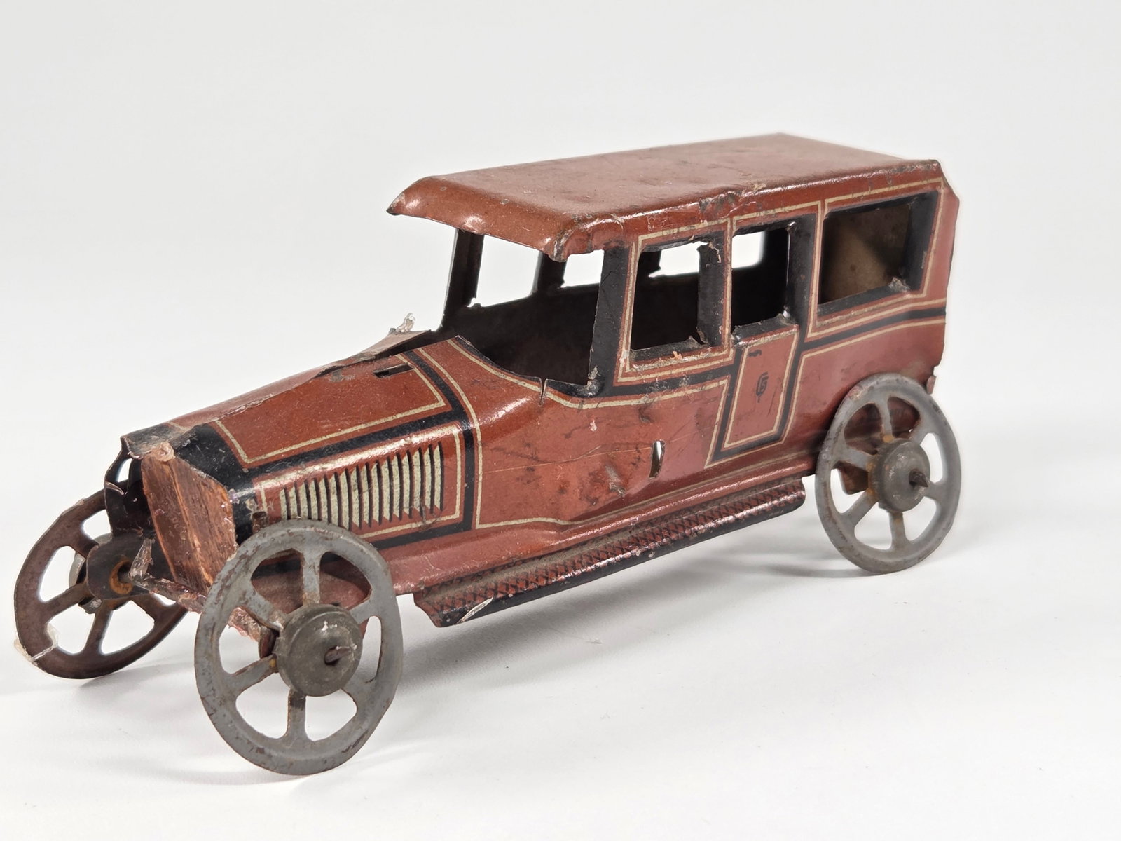 GEORG FISCHER TIN LITHO GERMAN PENNY TOY AUTOMOBILE: REMAINS IN FAIR CONDITION, SHOWING WEAR WITH BENDS THROUGHOUT.