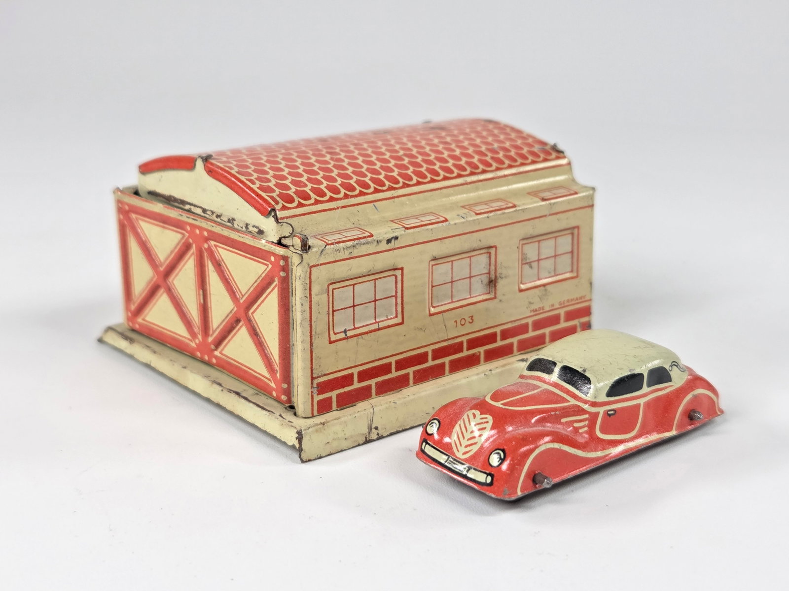 GERMAN TIN LITHO GARAGE W/ CAR - CREAM & RED: REMAINS IN GOOD CONDITION, SHOWING SOME TYPICAL WEAR.