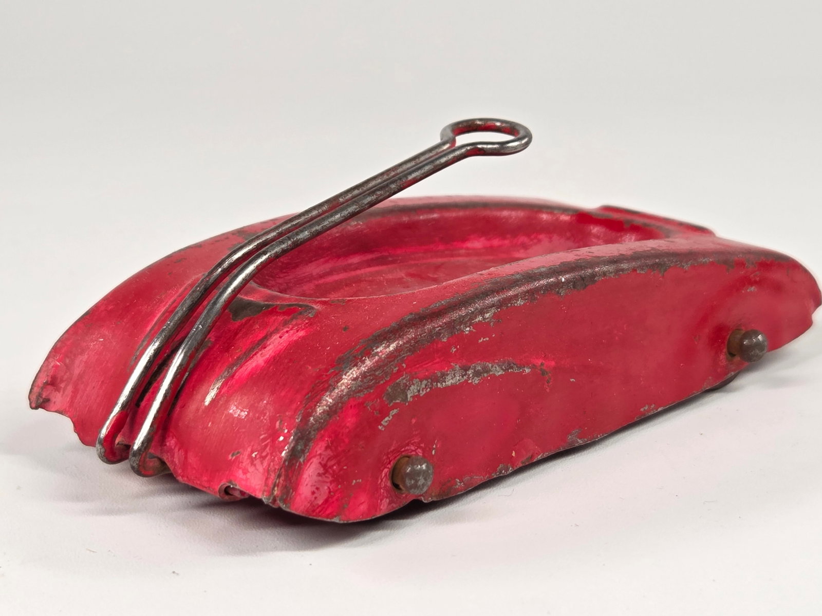 RED PAINTED PRESSED STEEL STREAMLINE WAGON: REMAINS IN FAIR CONDITION, SHOWING SOME WEAR. PAINTED RED IN SPOTS.