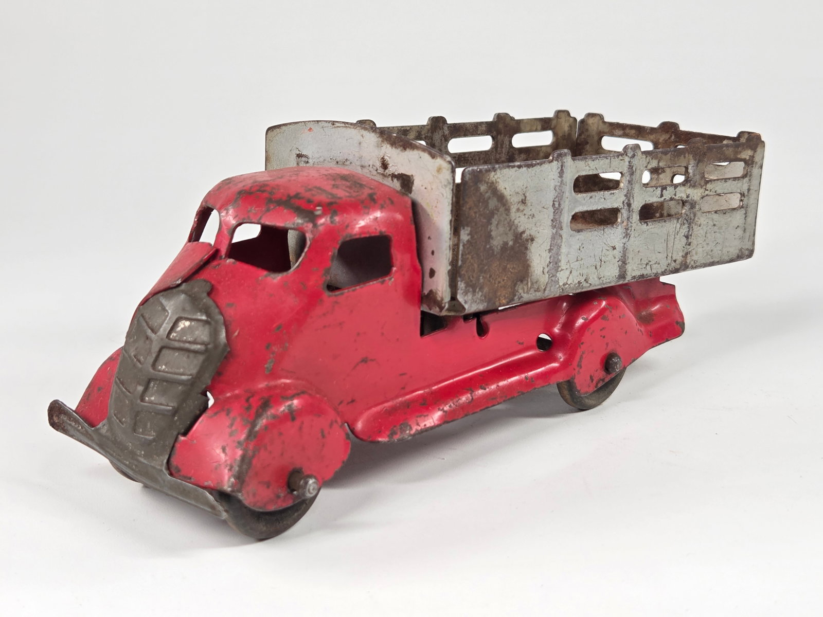 MARX PRESSED STEEL STAKE BODY TRUCK: REMAINS IN FAIR CONDITION, SHOWING WEAR THROUGHOUT. ONE WHEEL BROKEN.