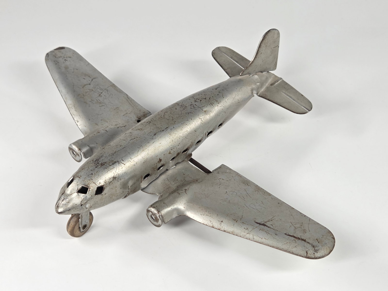 MARX PRESSED STEEL AIRPLANE: REMAINS IN FAIR TO GOOD CONDITION, SHOWING SOME TYPICAL WEAR. MISSING PROPELLERS
