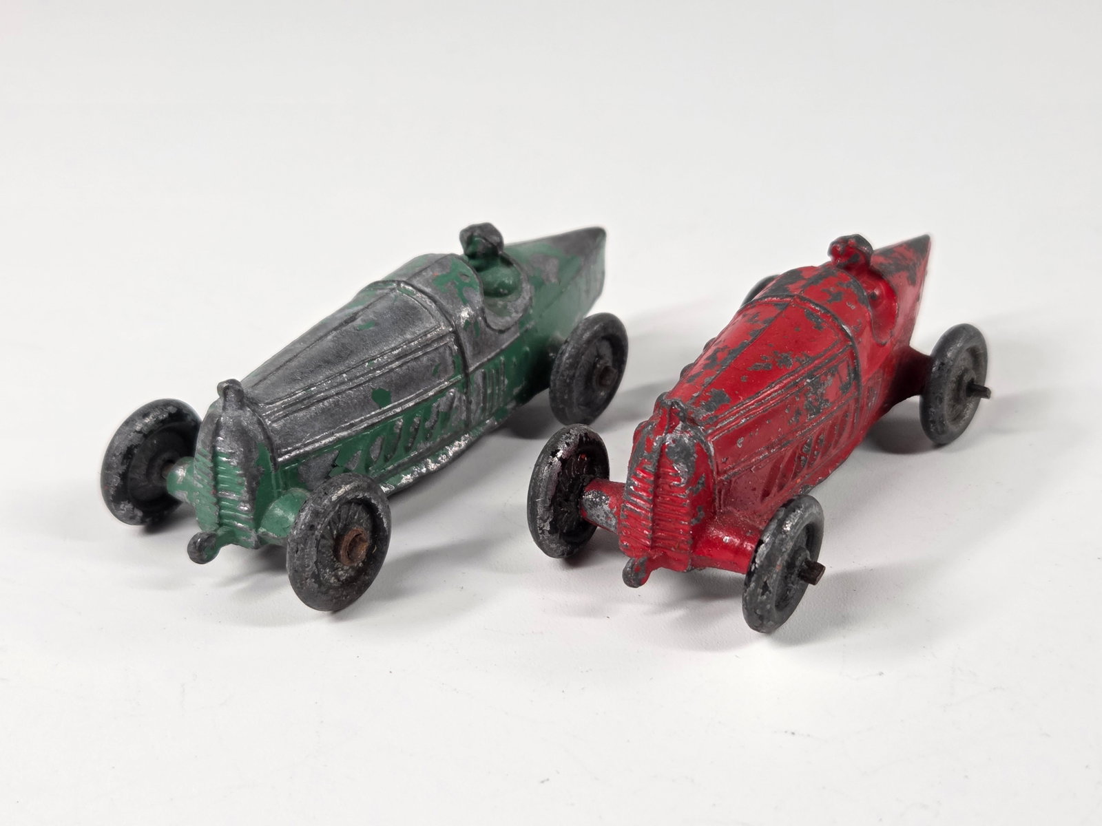 PAIR OF ANTIQUE SLUSH METAL BOAT TAIL RACE CARS: BOTH REMAIN IN FAIR CONDITION, SHOWING PAINT WEAR.