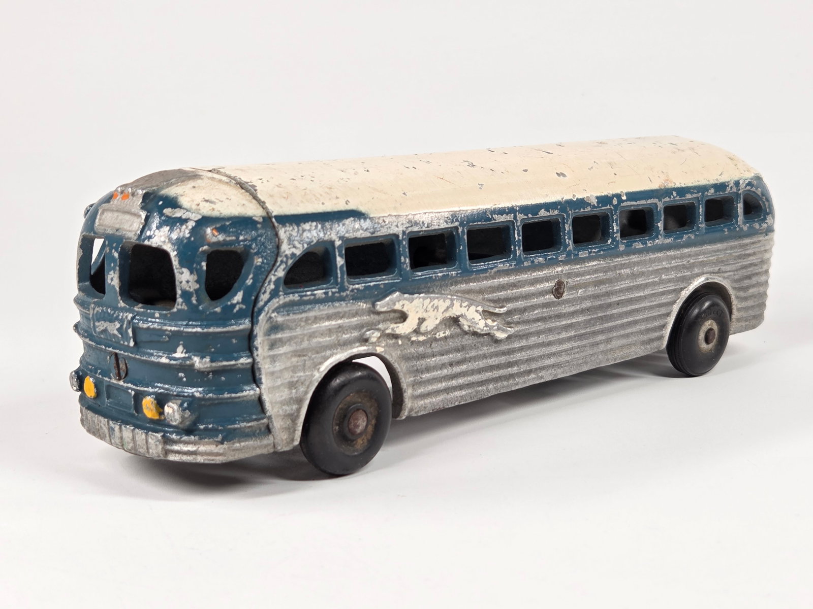CAST ALUMINUM PAINTED GREYHOUND BUS: REMAINS IN FAIR TO GOOD CONDITION, SHOWING SOME TYPICAL PAINT WEAR.