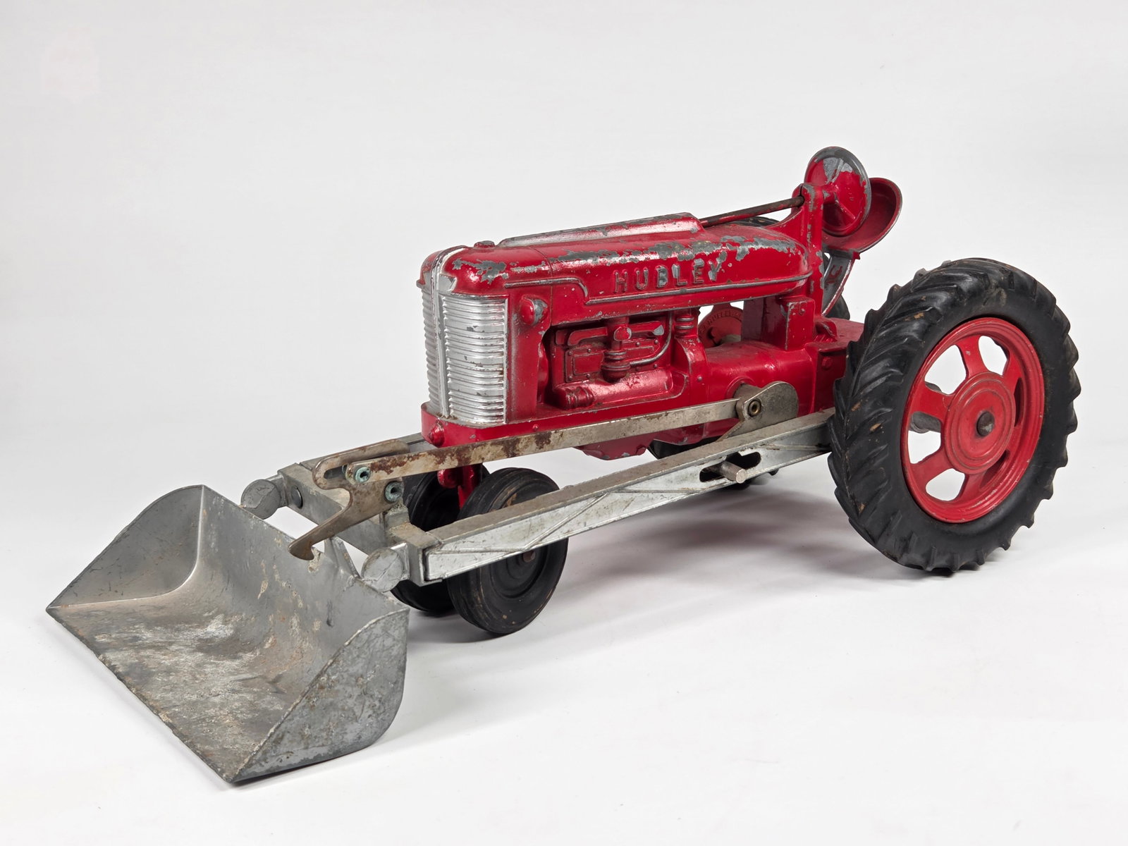 HUBLEY CAST METAL FARM TRACTOR W/ LOADER: REMAINS IN FAIR TO GOOD CONDITION, SHOWING TYPICAL PAINT WEAR.