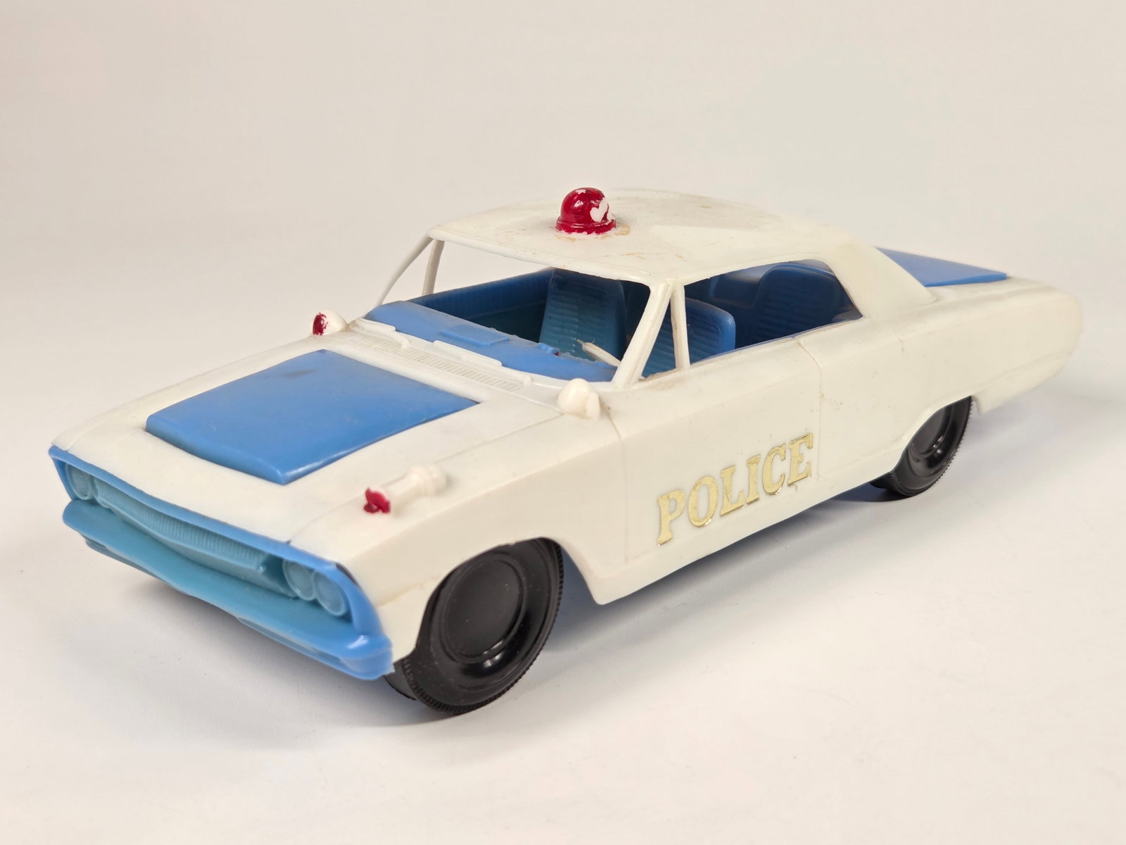 VINTAGE PLASTIC FORD POLICE CAR: REMAINS IN GOOD CONDITION, SHOWING SOME TYPICAL WEAR.