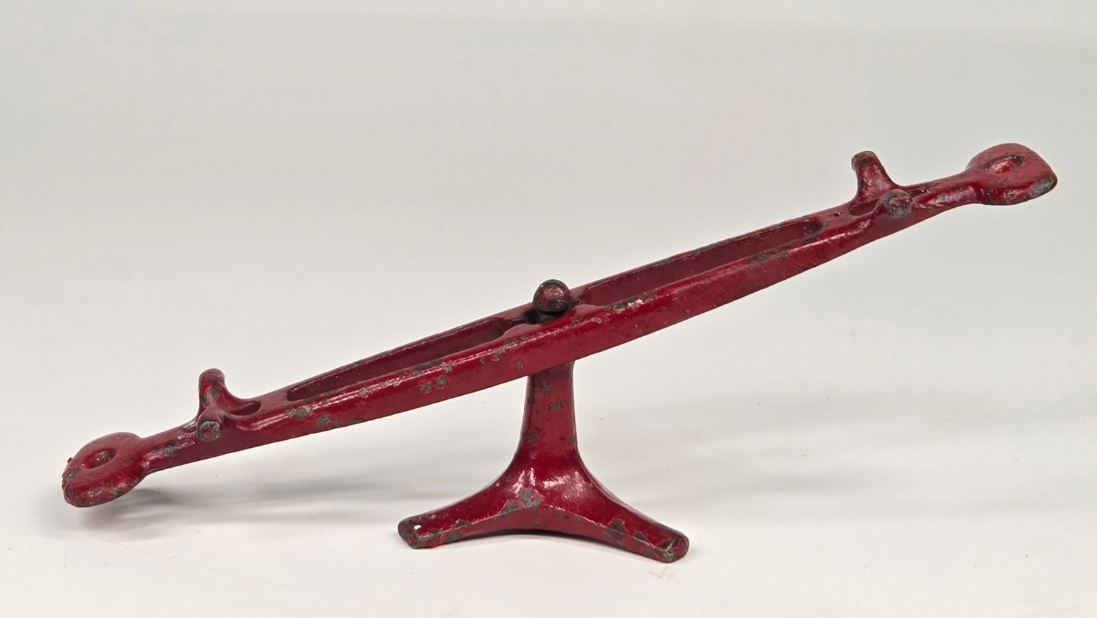 ANTIQUE CAST IRON MINIATURE SEESAW TOY: REMAINS IN GOOD CONDITION, SHOWING SOME PAINT WEAR.