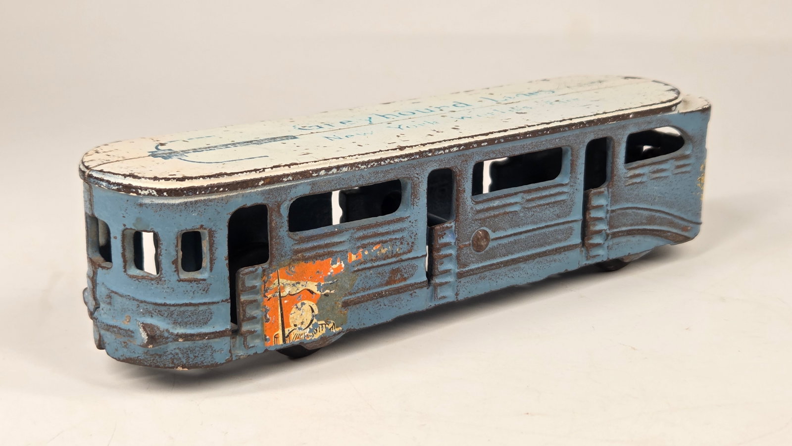 ARCADE CAST IRON WORLD'S FAIR GREYHOUND BUS LINES: REMAINS IN FAIR TO GOOD CONDITION, SHOWING PAINT WEAR / DECAL WEAR.