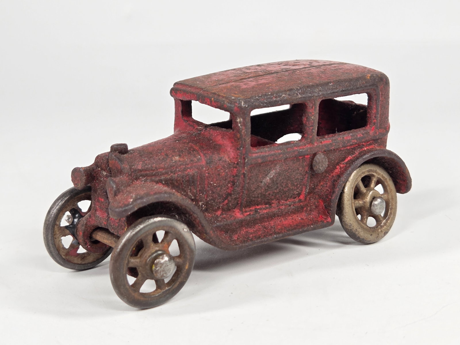 ANTIQUE CAST IRON RED PAINTED SEDAN: REMAINS IN FAIR CONDITION, SHOWING PAINT WEAR THROUGHOUT.