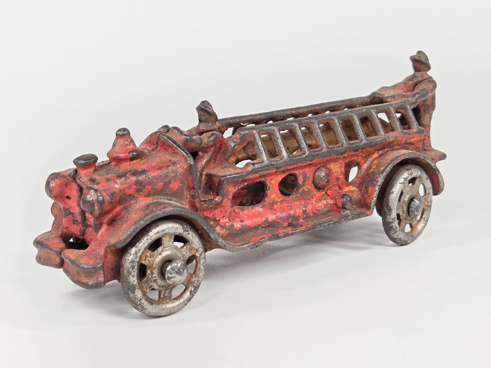 AC WILLIAMS CAST IRON FIRE ENGINE LADDER TRUCK: REMAINS IN FAIR TO GOOD CONDITION, SHOWING PAINT WEAR THROUGHOUT.