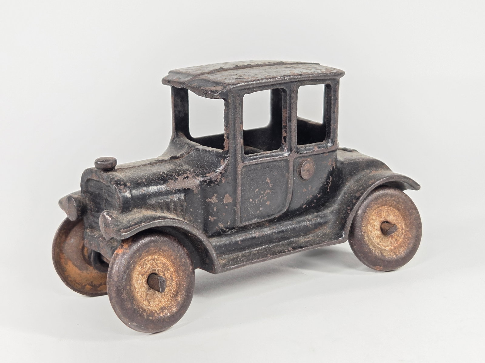 ANTIQUE CAST IRON FORD COUPE: REMAINS IN FAIR CONDITION, SHOWING PAINT WEAR THROUGHOUT.