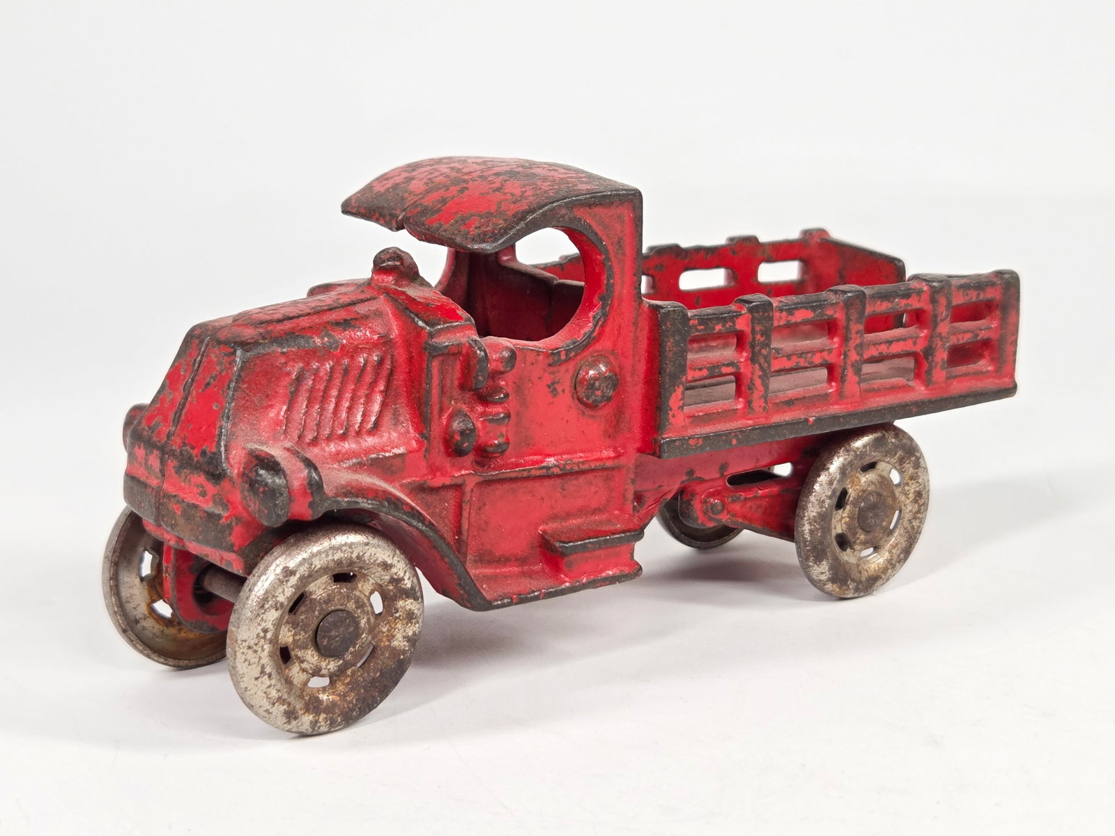 CAST IRON MACK C CAB STAKE BODY TRUCK: REMAINS IN FAIR TO GOOD CONDITION, SHOWING SOME PAINT WEAR.