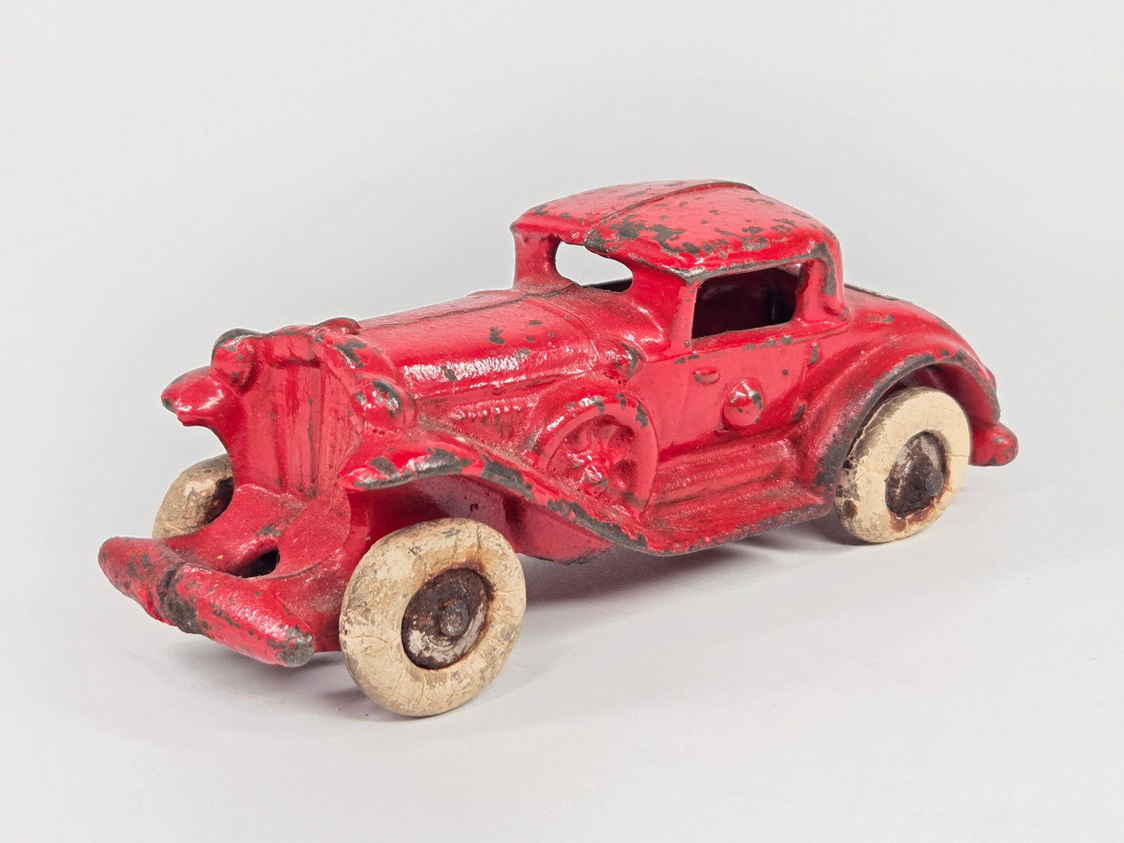 CHAMPION CAST IRON 3 WINDOW COUPE W/ RUMBLE SEAT: REMAINS IN FAIR TO GOOD CONDITION, SHOWING PAINT WEAR. WHEELS SHOW OLDER REPLACEMENTS.
