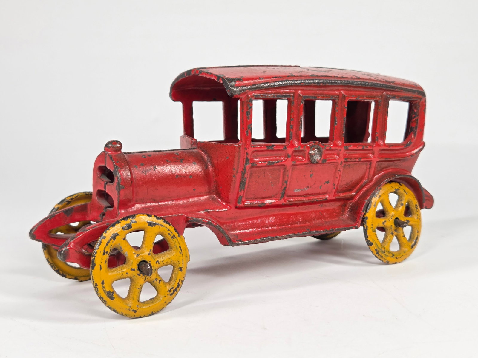 ANTIQUE CAST IRON SEDAN W/ YELLOW SPOKE WHEELS: REMAINS IN FAIR TO GOOD CONDITION, SHOWING PAINT WEAR.