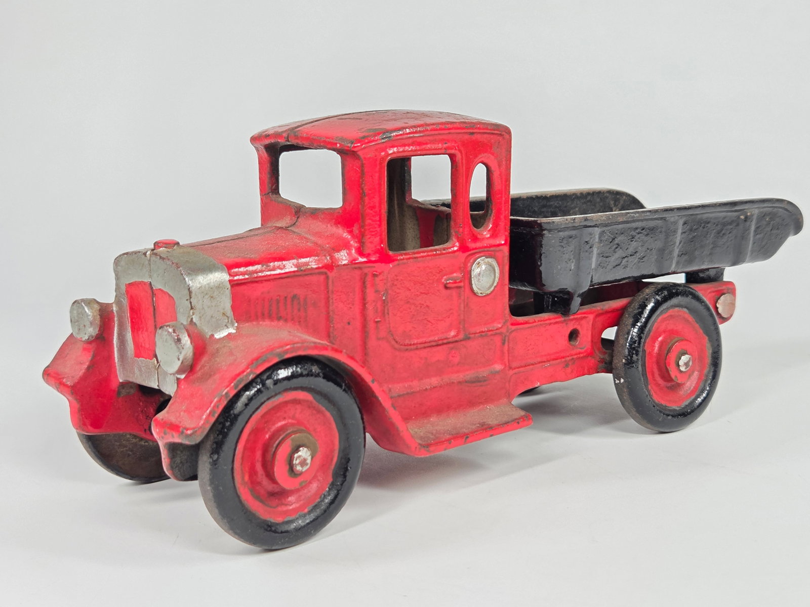 PAINTED CAST IRON DUMP TRUCK: REMAINS IN FAIR CONDITION, SHOWING WEAR. COMPLETELY PAINTED OVER.