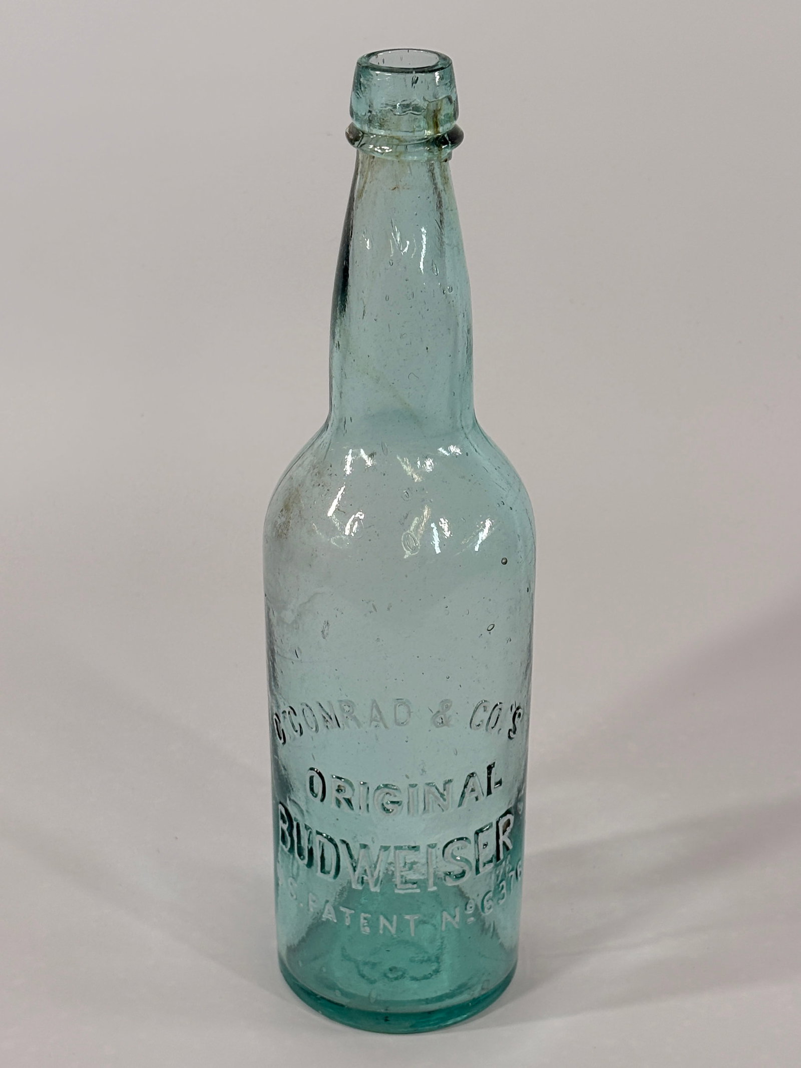 FIRST AQUA BLUE ORIGINAL BUDWEISER BEER BOTTLE C. CONRAD EMBOSSED: CIRCA 1870-80 BOTTLE REMAINS IN VERY GOOD CONDITION WITH LIGHT GENERAL WEAR
