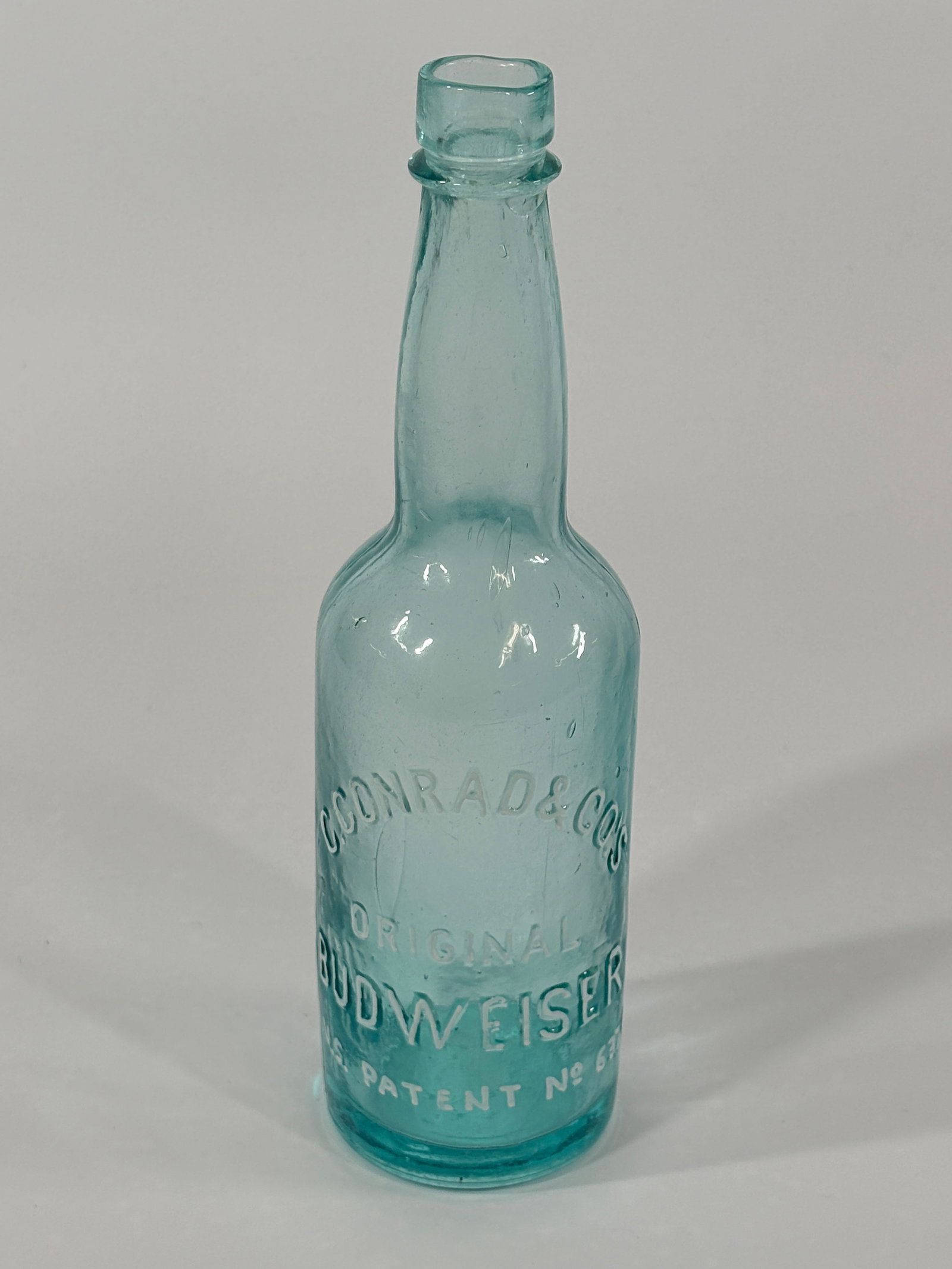 FIRST AQUA BLUE ORIGINAL BUDWEISER BEER BOTTLE C. CONRAD EMBOSSED: CIRCA 1870-80 BOTTLE REMAINS IN VERY GOOD CONDITION WITH LIGHT GENERAL WEAR