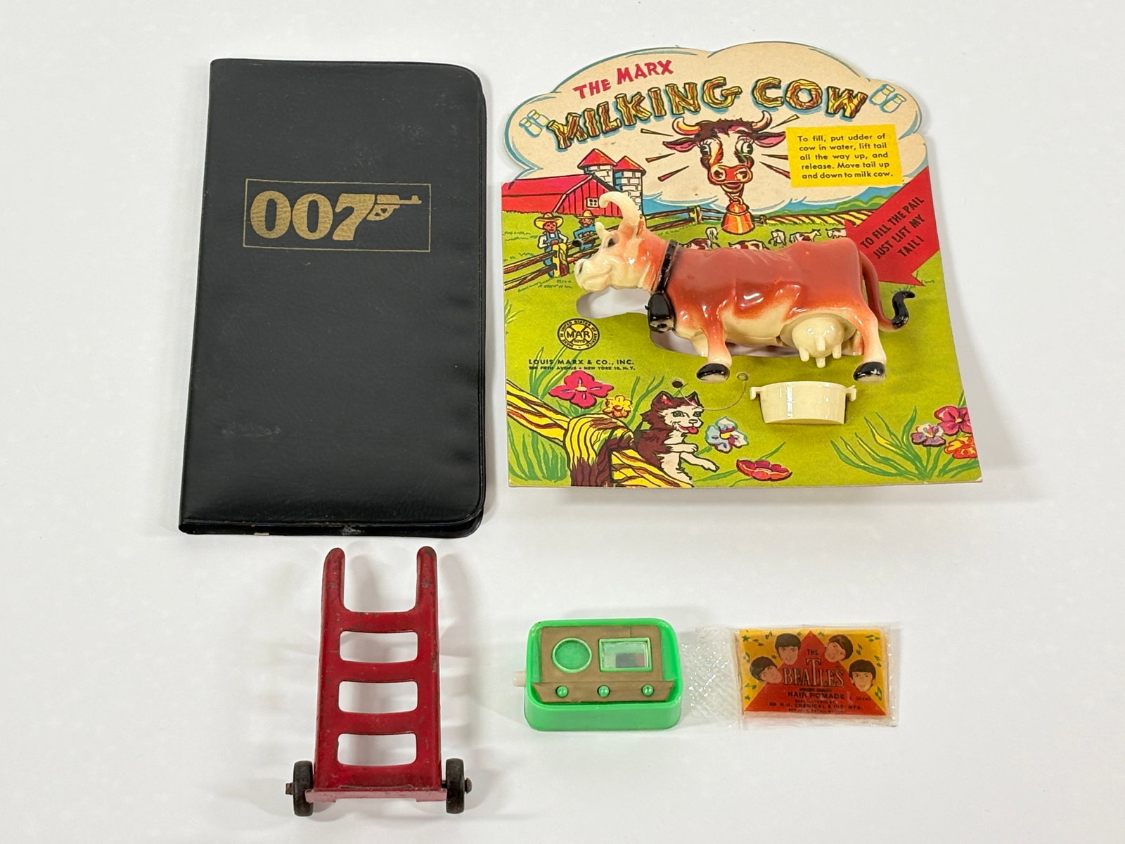 007 JAMES BOND, MARX MILKING COW, BEATLES POMADE: ALL ITEMS REMAIN IN GOOD CONDITION. SHOWING LIGHT WEAR.
