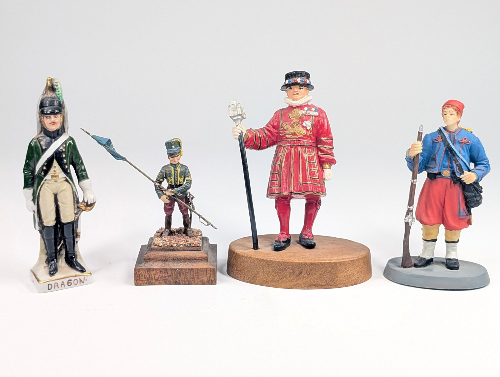 4) HAND PAINTED SOLDIER FIGURINES: ALL REMAIN IN GOOD CONDITION, SHOWING SOME PAINT WEAR. DRAGON FIGURE IN PORCELAIN.