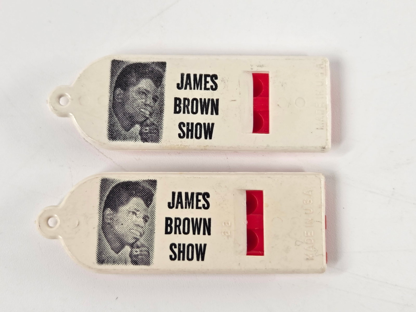 2) 1950'S JAMES BROWN SHOW SOUVENIR CONCERT WHISTLES: BOTH REMAIN IN VERY GOOD CONDITION WITH MILD SIGNS OF WEAR