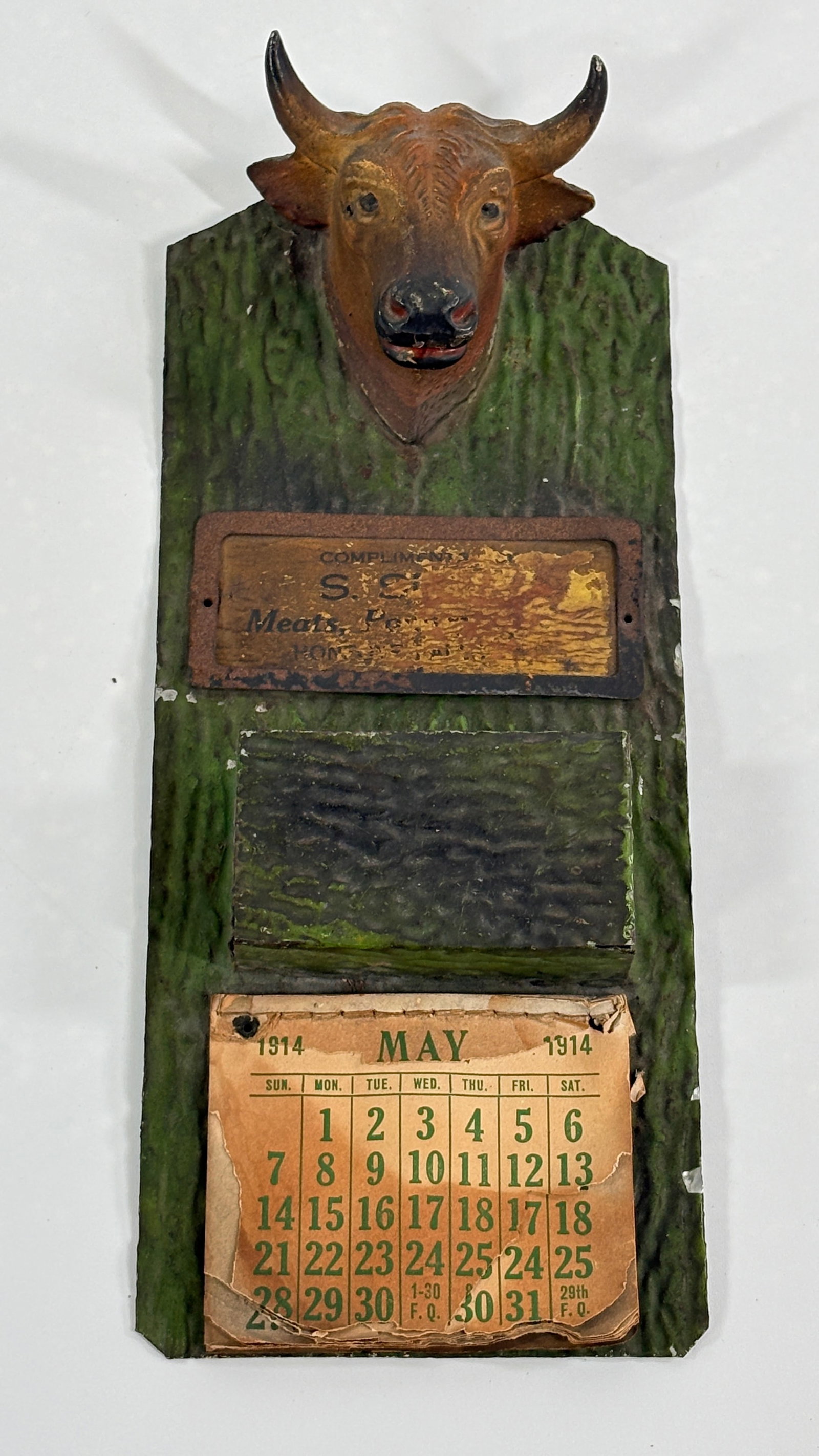 1914 S.S. MEAT ADVERTISING CAST METAL BULL HEAD MATCH HOLDER: REMAINS IN FAIR TO GOOD CONDITION, SHOWING SOME TYPICAL WEAR. MISSING SOME OF THE CALENDAR PAGES.