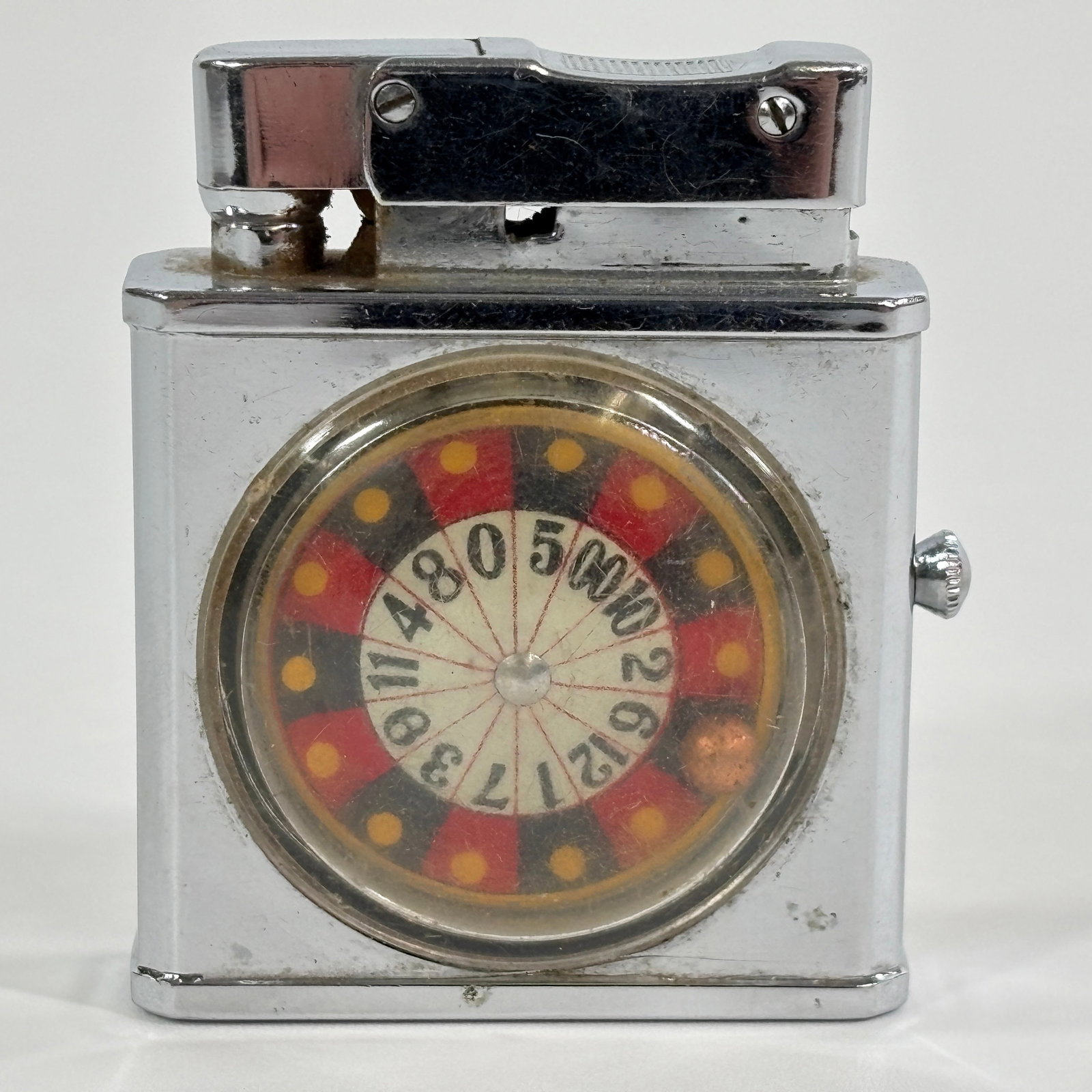 VINTAGE MONTE CARLO ROULETTE WHEEL ADVERTISING LIGHTER: REMAINS IN GOOD CONDITION, SHOWING SOME TYPICAL WEAR.