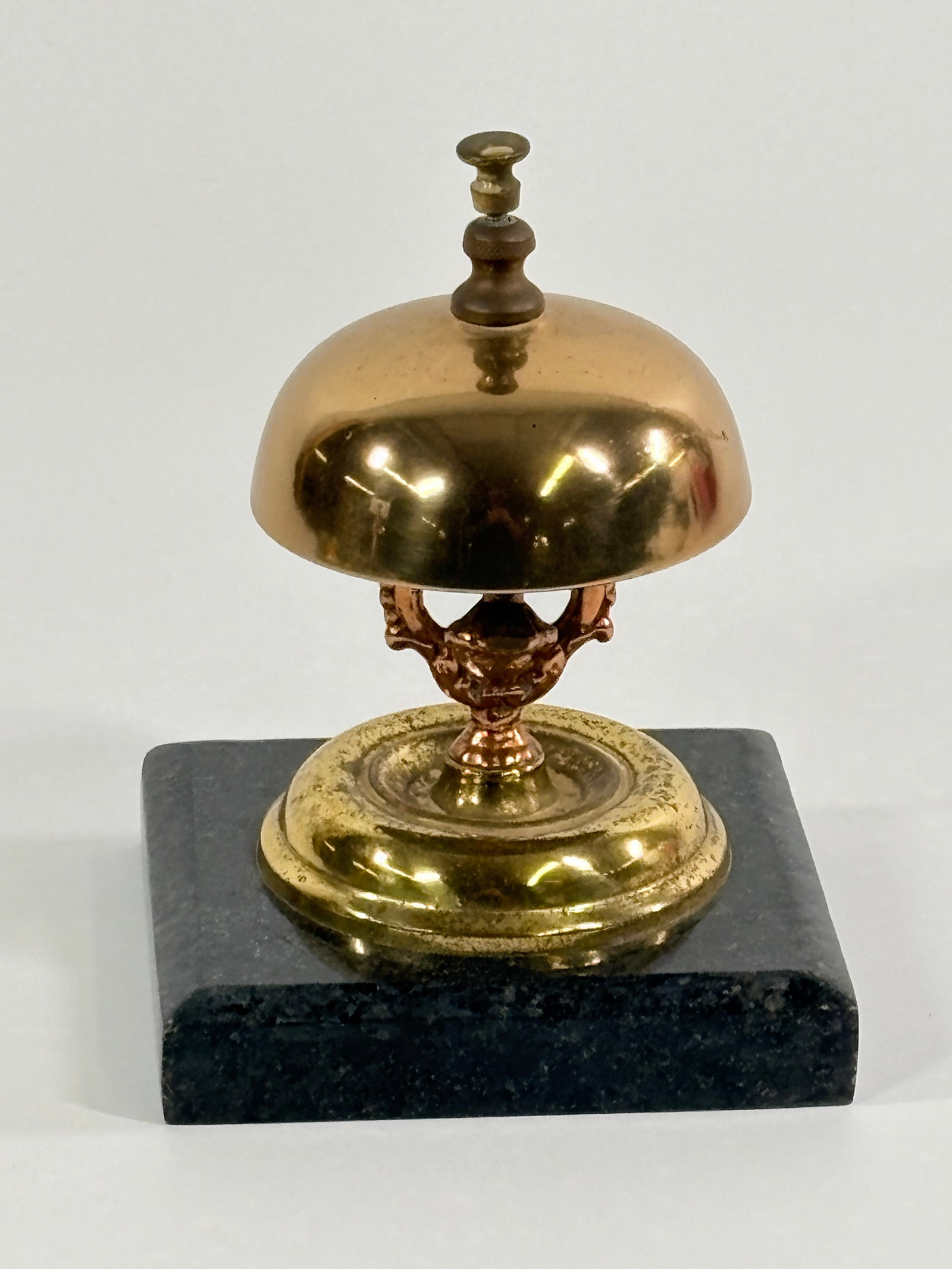 ANTIQUE POLISHED BRASS HOTEL BELL ON MARBLE BASS: REMAINS IN GOOD CONDITION, SHOWING SOME WEAR.