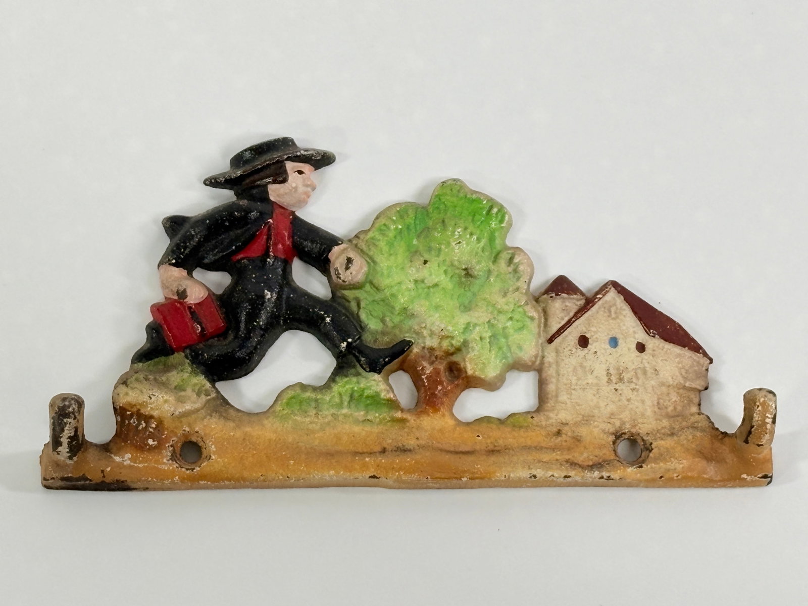 PAINTED CAST IRON AMISH SCHOOL WALL HOOK: REMAINS IN GOOD CONDITION, SHOWING SOME PAINT WEAR.