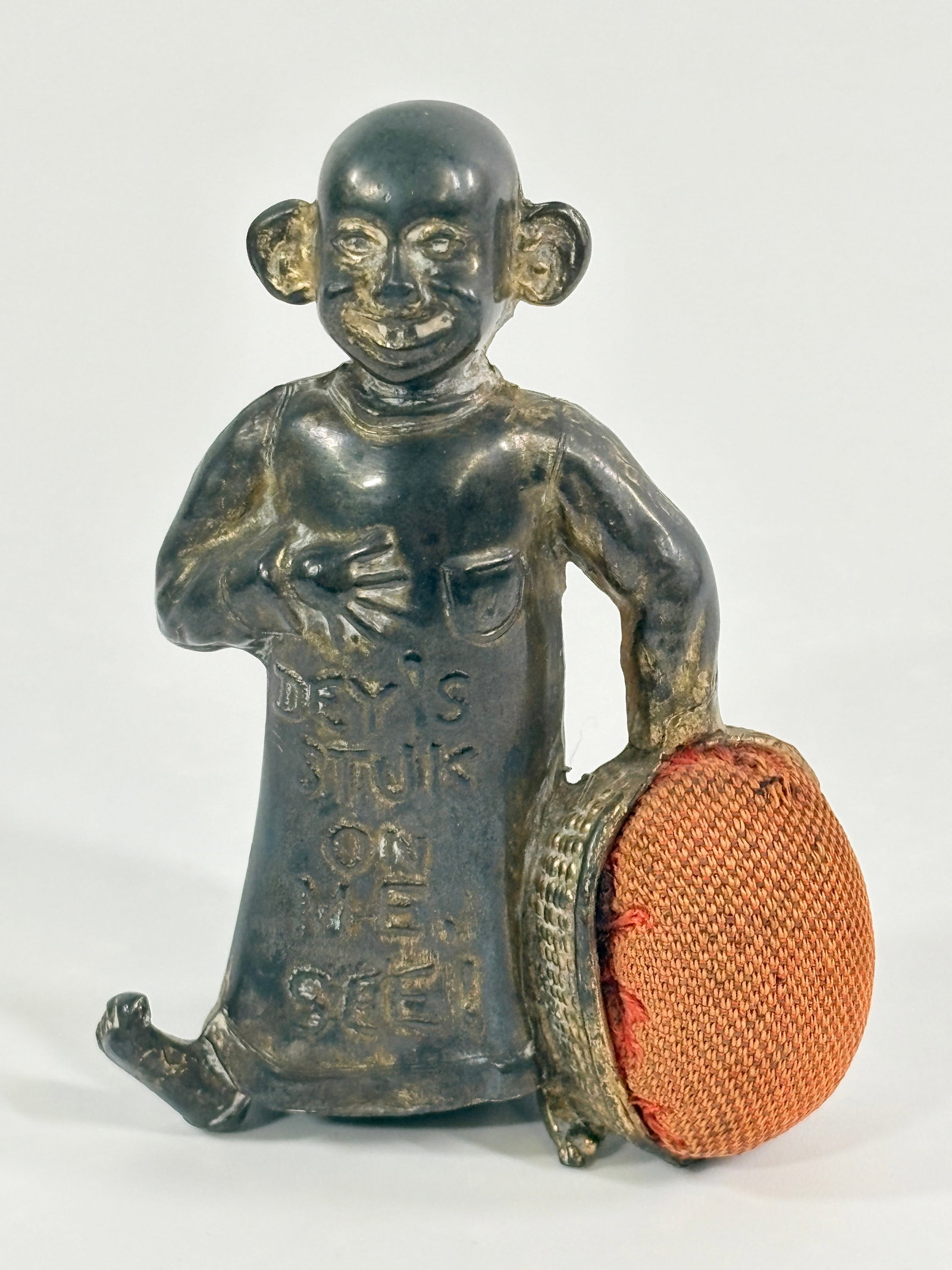 ANTIQUE CAST METAL THE YELLOW KID PIN CUSHION: REMAINS IN FAIR TO GOOD CONDITION, SHOWING TYPICAL USAGE WEAR THROUGHOUT.