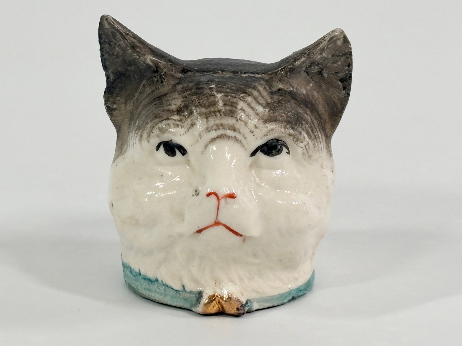 ANTIQUE GERMAN BISQUE PAINTED CAT HEAD STILL BANK: REMAINS IN GOOD CONDITION, SHOWING SOME LIGHT WEAR.