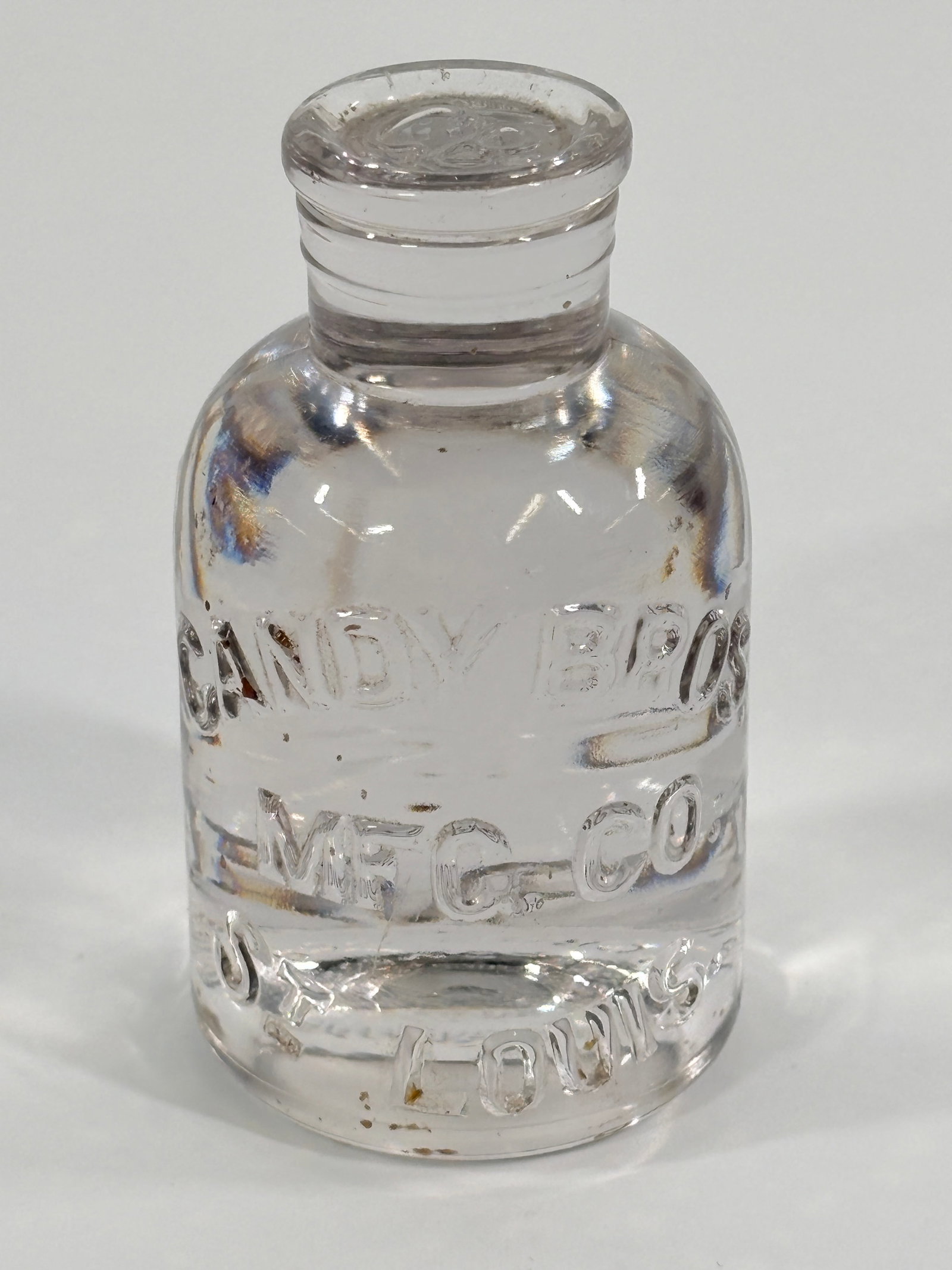 ANTIQUE CANDY BROS MFG. CO. GLASS BOTTLE PAPERWEIGHT: REMAINS IN GOOD CONDITION.