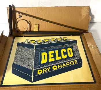 Delco Battery double sided painted metal sign.  NOS sign features original shipping box, hanging: Delco Battery double sided painted metal sign. NOS sign features original shipping box, hanging bracket and hardware. Presents in new old stock condition with shelf wear.