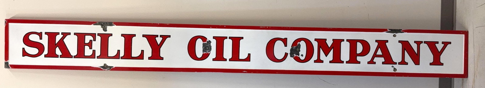 Skelly Oil Company Porcelain Sign: Skelly Oil Company single sided self-framing "cookie cutter" style porcelain sign. This filling station bay sign dates to the 1930's and presents with nice color and a few chips. Measures 12x114.