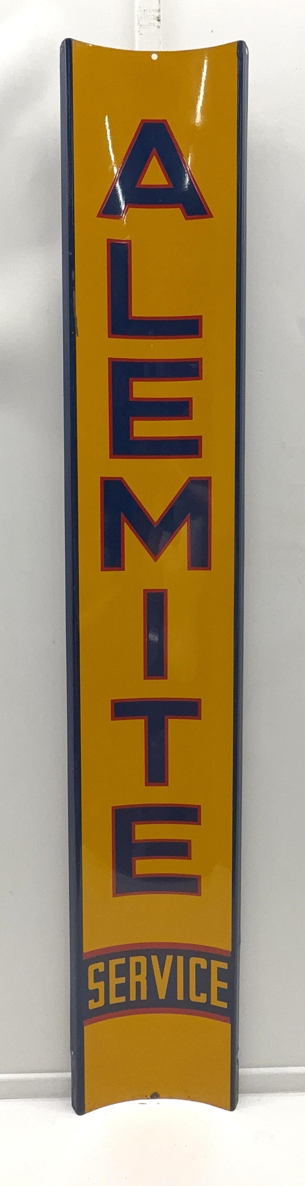 Alemite Service Rounded Metal Vertical Sign: Alemite Service painted metal single sided sign.? Unique rounded design and presents with strong color and light wear.? Measures 56x10.
