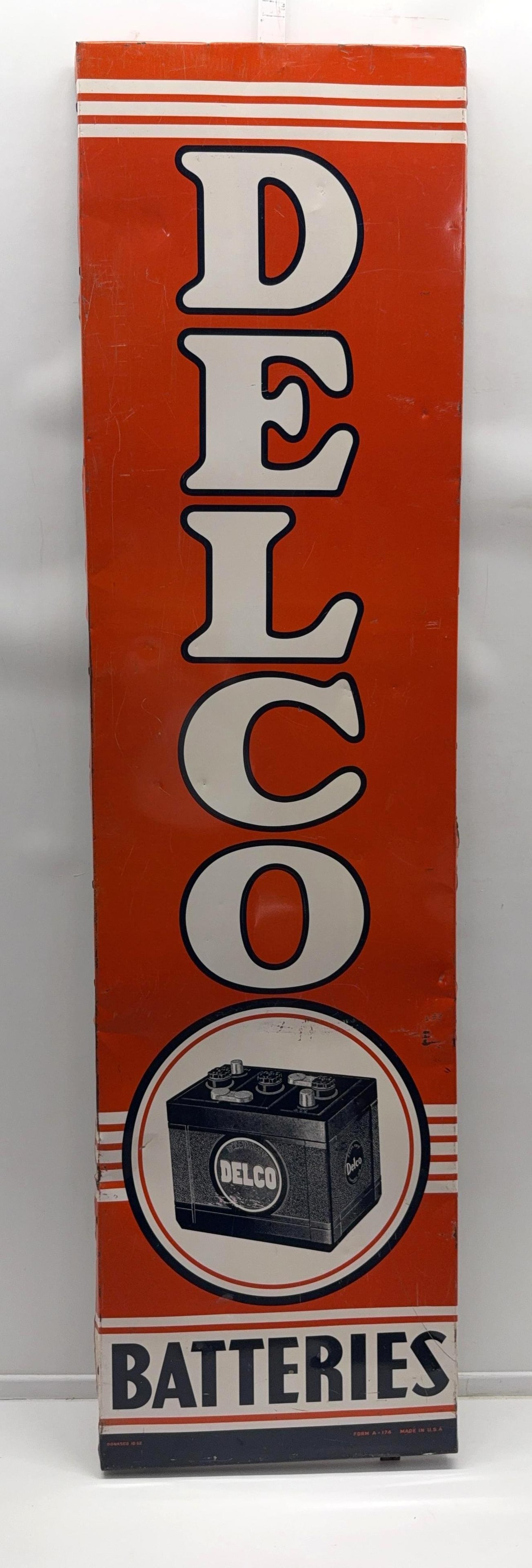 1952 Delco Batteries Metal Sign: Delco Batteries single sided painted metal sign.? Dated 1952, features Delco Battery image and original wood frame.? Presents with good color and some wear.? Measures 70x19.