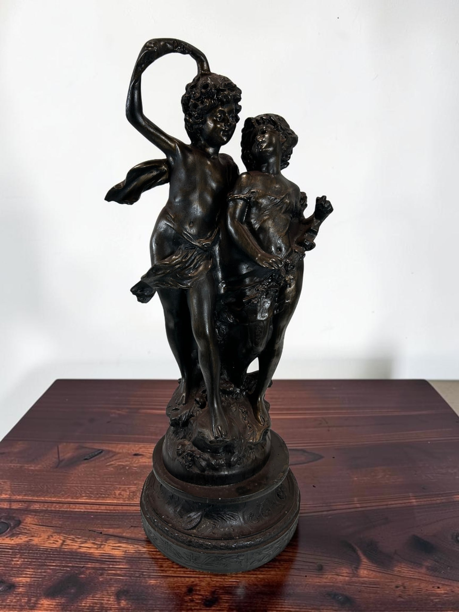 Large Antique French Cold Cast Resin Bronze Patinated Putti Cherub Sculpture After Clodion Style: This elegant large antique French cold cast resin bronze patinated sculpture depicts two playful putti cherubs in a dynamic dancing pose, capturing the romantic and expressive spirit of French decorat