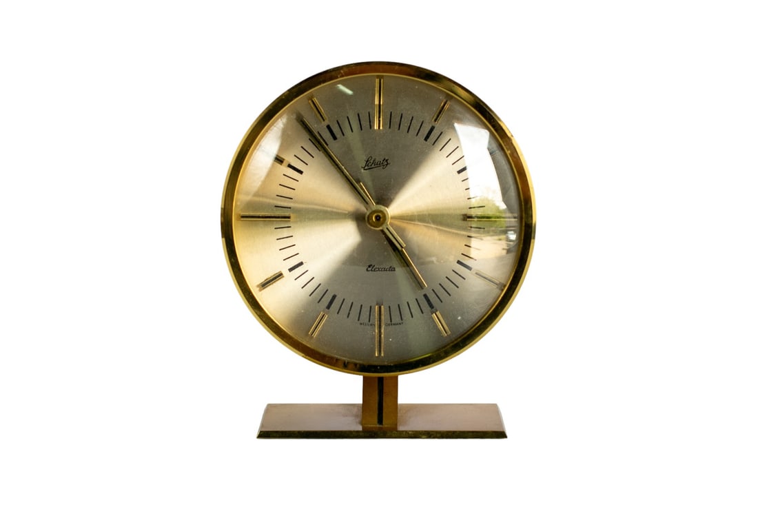 Mid-Century Vintage Aug. Schatz and Sohne Desk Clock, "Elexacta" Model: Step into the past with the Aug. Schatz and Sohne desk clock, a timeless piece that conjures the elegant spirit of the 1960s. Crafted from solid brass, this distinctive mantel clock, an original rare 