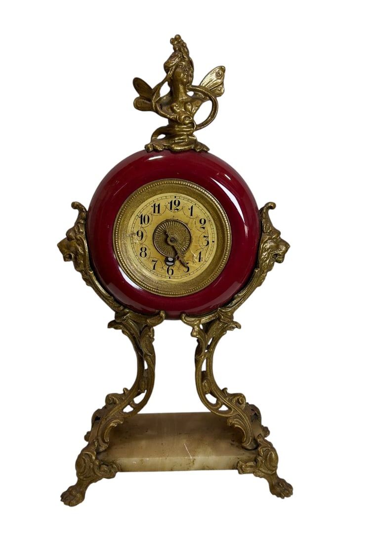 Antique Art Nouveau Rococo Red Enamel Mantel Clock with Bronze Figural Mounts: An elegant antique Art Nouveau mantel clock featuring a striking red painted glass circular body accented with ornate bronze figural mounts and a decorative onyx marble base. This highly decorative ti