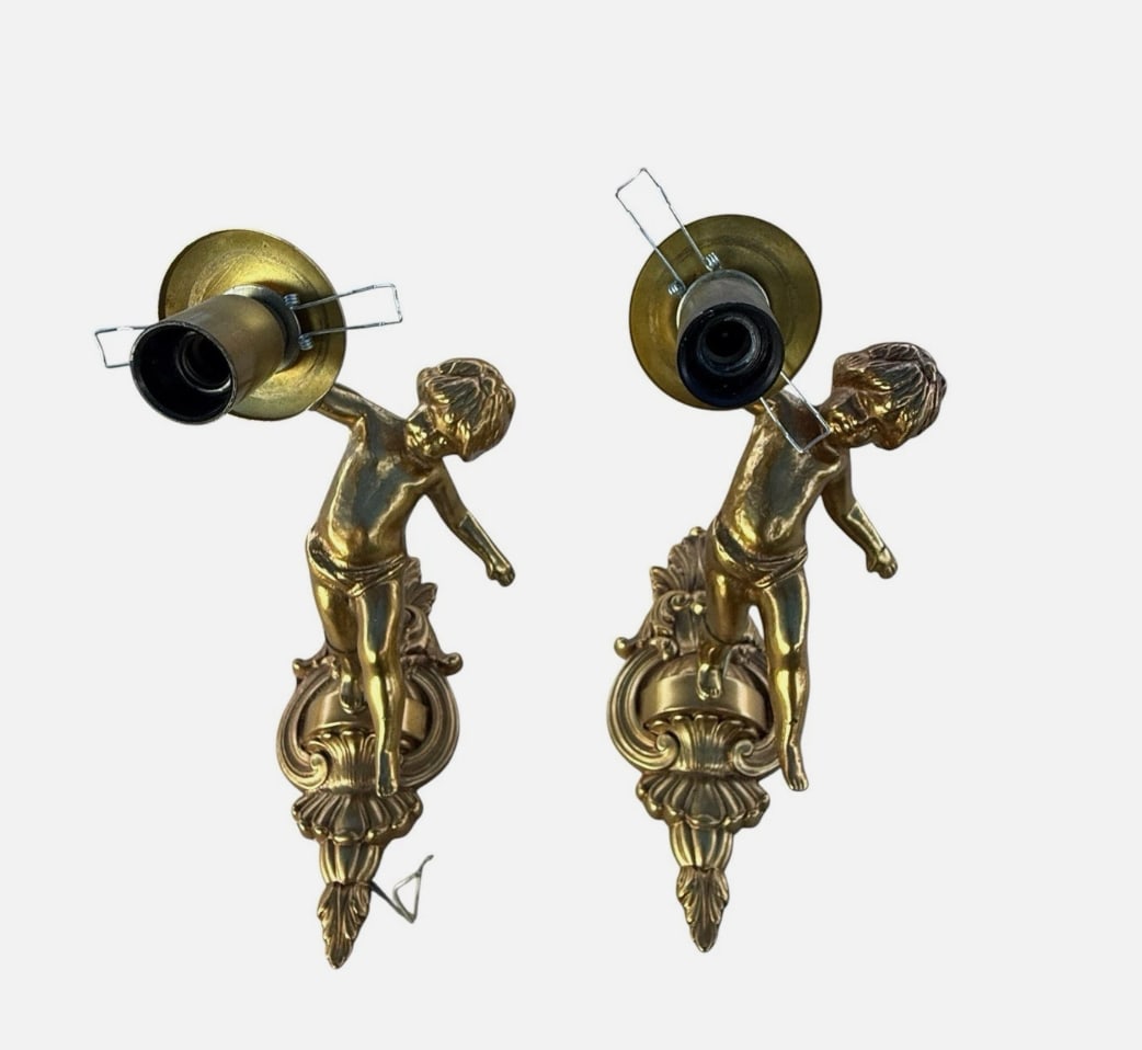 Vintage Pair Gilt Bronze Cherub Putti Wall Sconces Baroque Rococo Lights 8”: Decorative vintage pair of bronze wall sconces featuring sculptural cherub or putti figures. Each cherub holds a single upward-facing light above an ornate Rococo-style backplate embellished with scro
